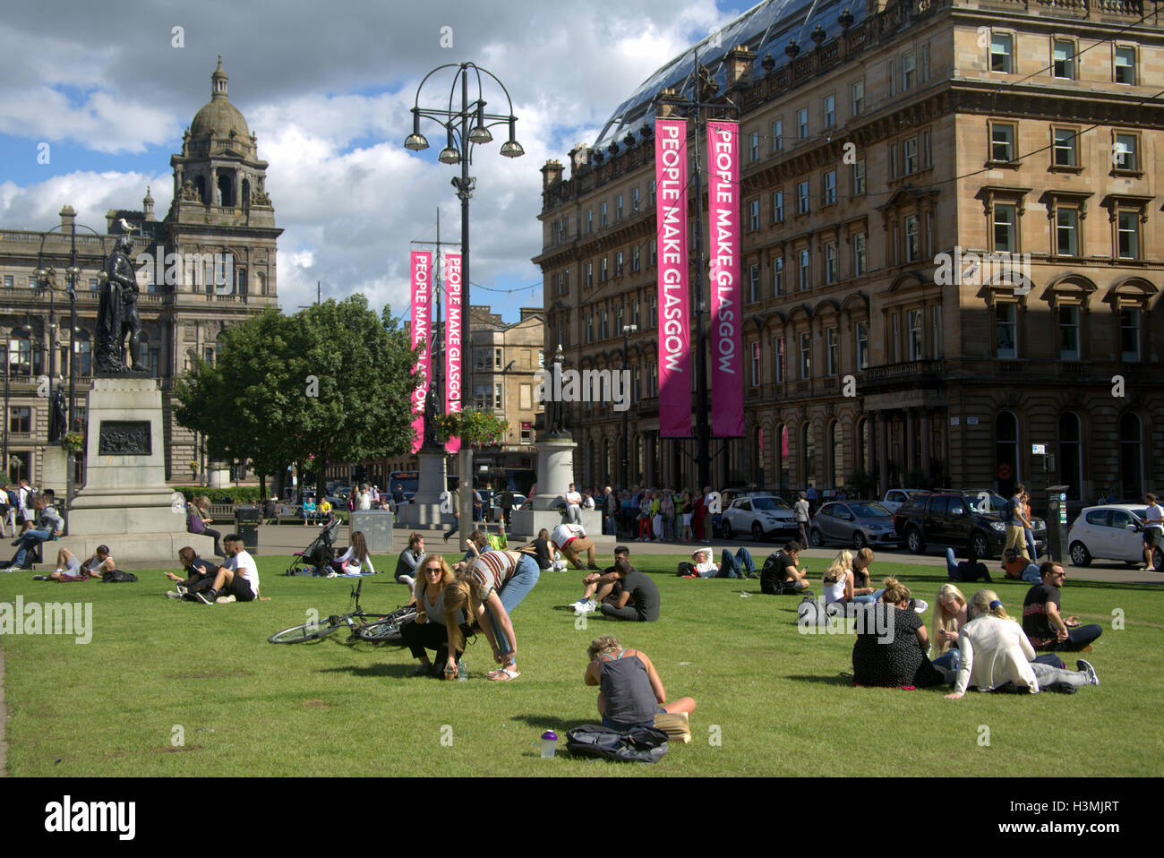 George Square et la ville chambres avec le cénotaphe situé dans le centre-ville de Glasgow center les habitants et les touristes se détendre et profiter du soleil Banque D'Images