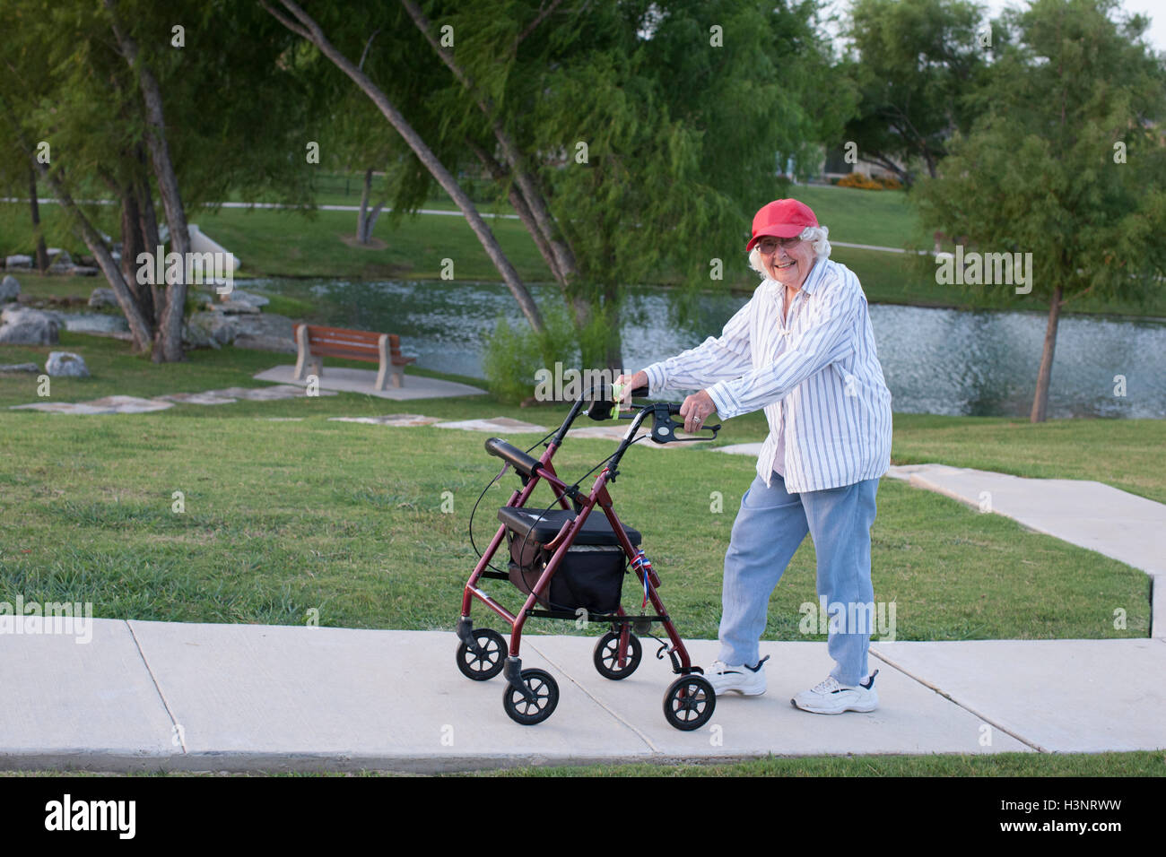 Senior woman walking outdoors avec déambulateur Banque D'Images