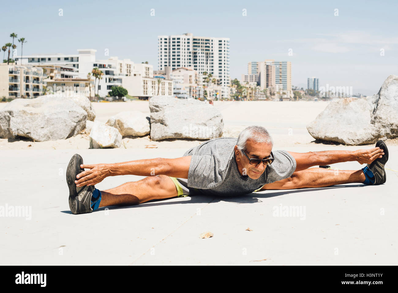 Man, l'exercice sur la plage, stretching, Long Beach, Californie, USA Banque D'Images