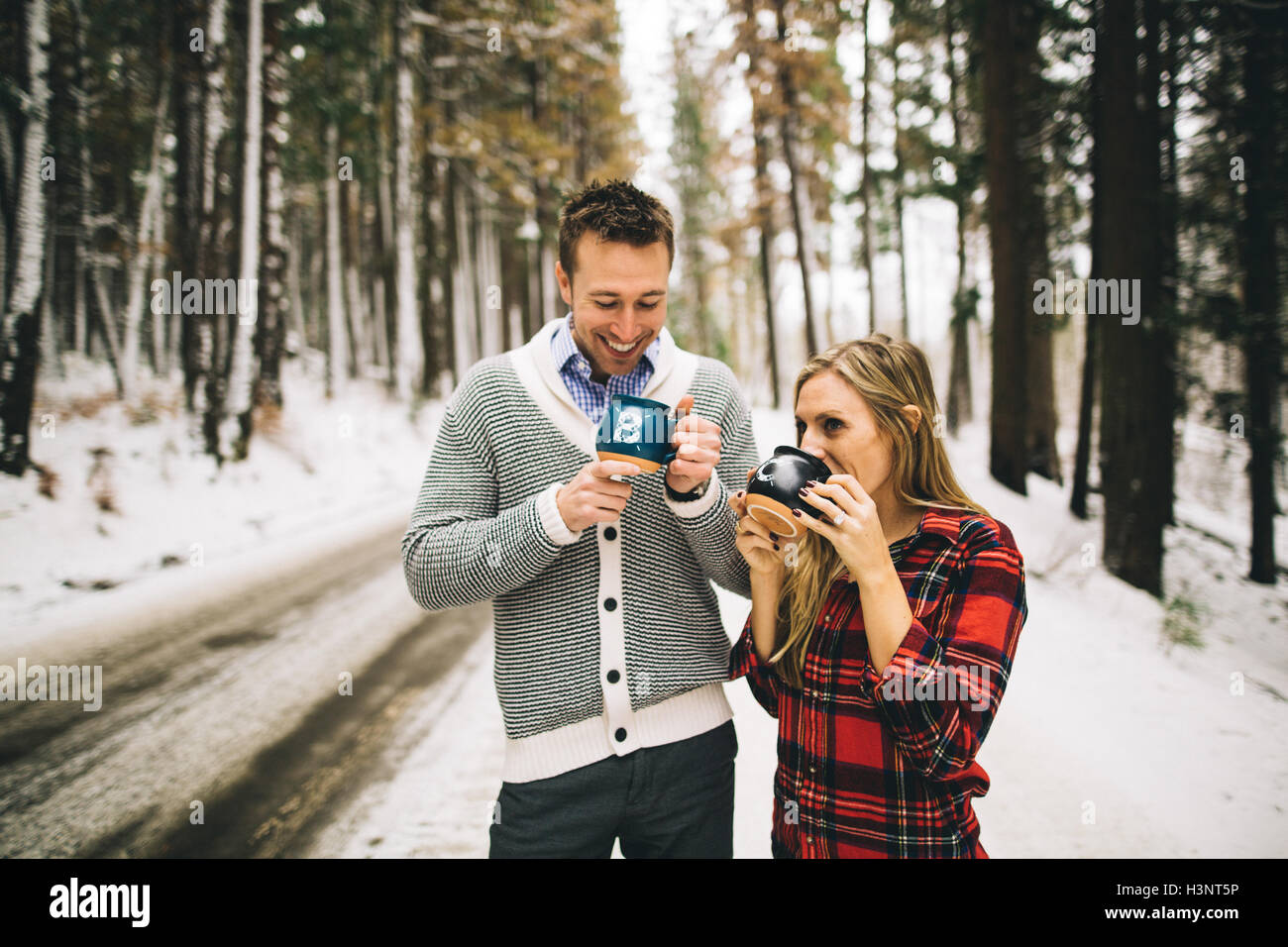 Couple dans la forêt couverte de neige de boire de boissons chaudes café, Banque D'Images