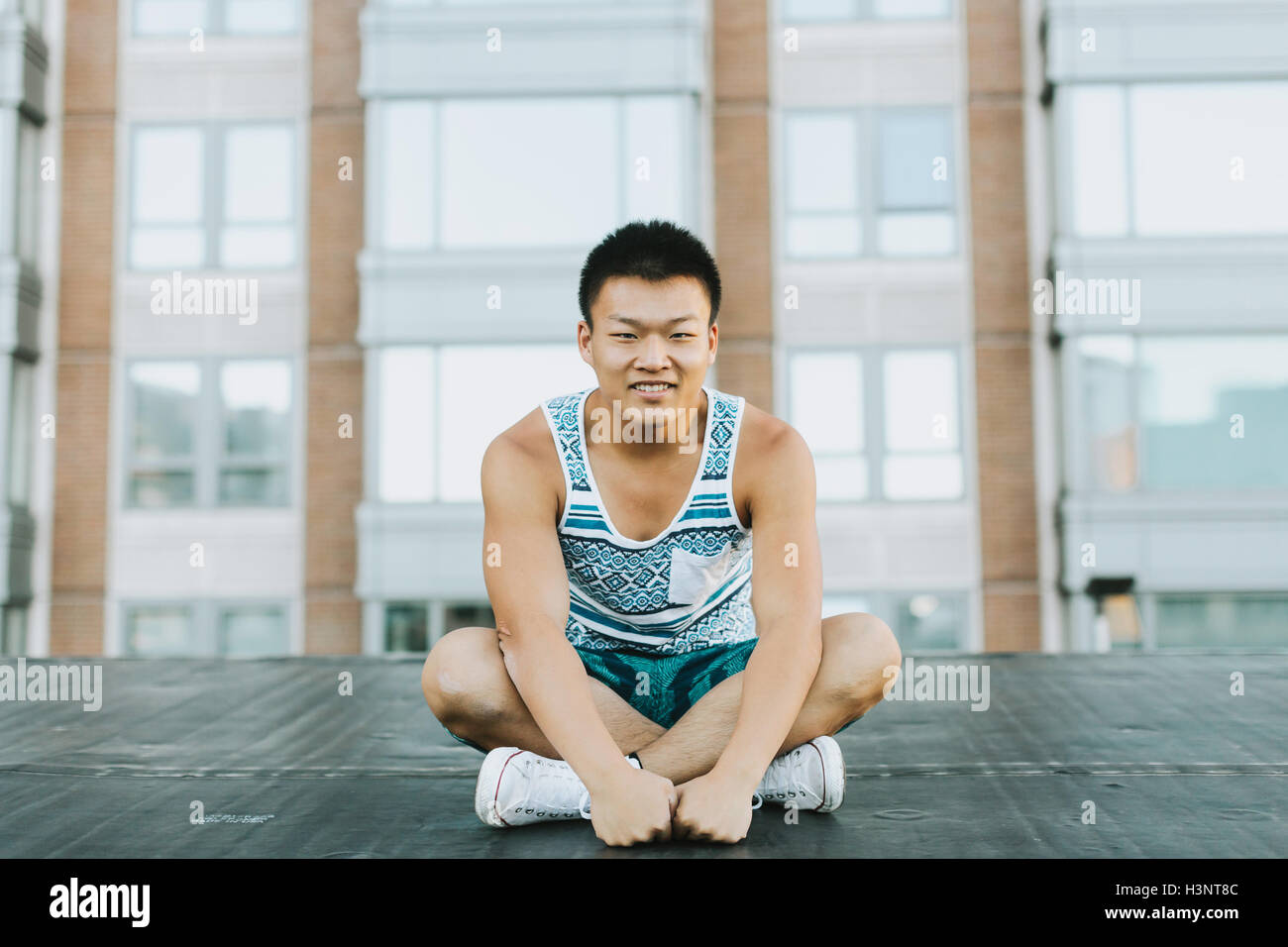 Homme assis les jambes croisées sur le sol en béton, Boston, Massachusetts, USA Banque D'Images