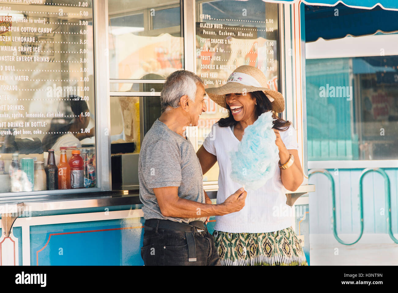 Couple debout à côté buvette, holding Cotton Candy, Long Beach, Californie, USA Banque D'Images