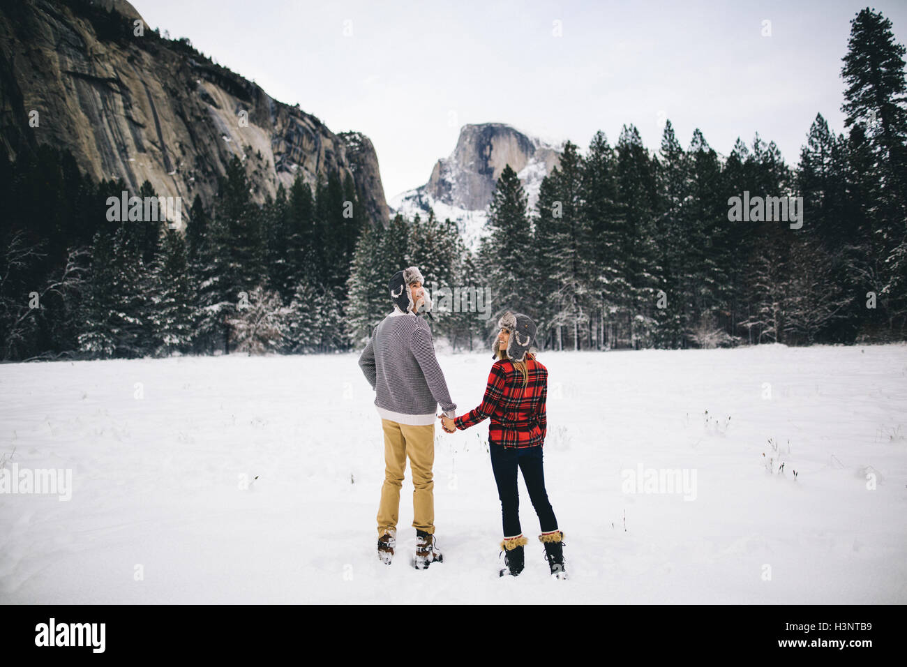 Vue arrière du couple holding hands on paysage enneigé Banque D'Images