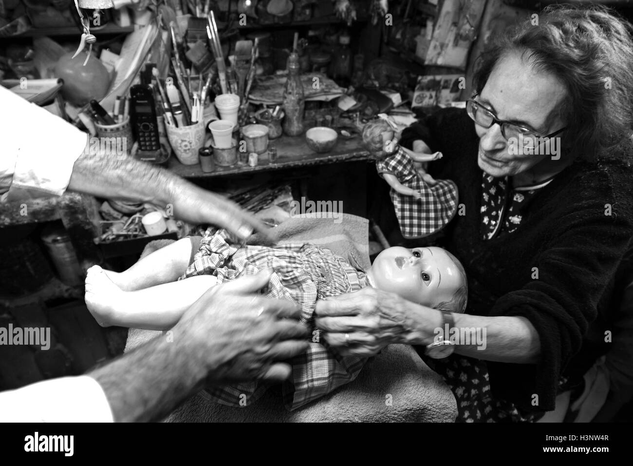 Les artisans Federico et Gelsy habiller un reapired poupée dans la restauration boutique appelé 'Doll Hôpital" dans la via di Ripetta, Rome Banque D'Images