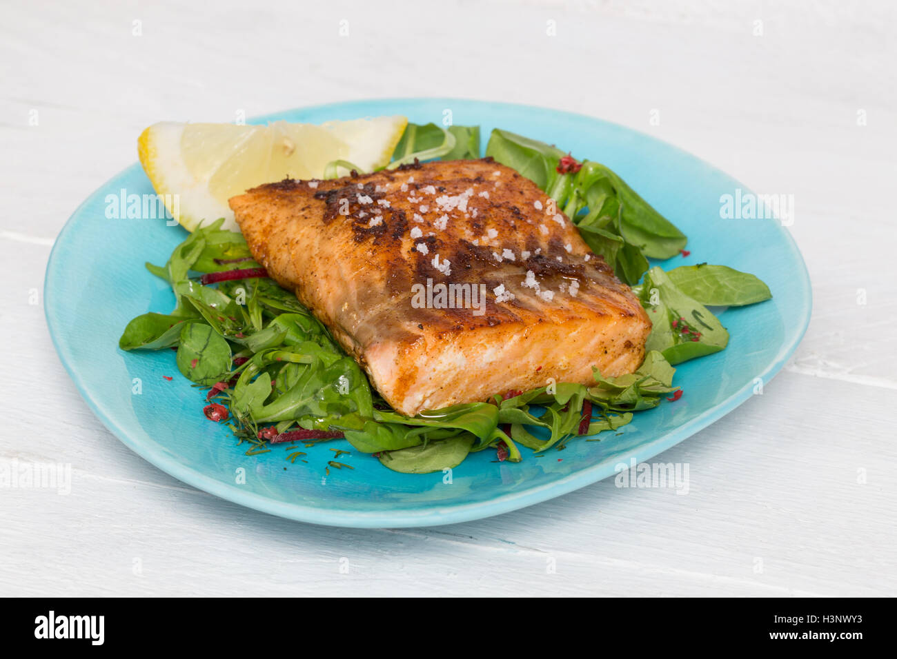 Filet de saumon poêlé à la fleur de sel sur la salade mixte. Banque D'Images