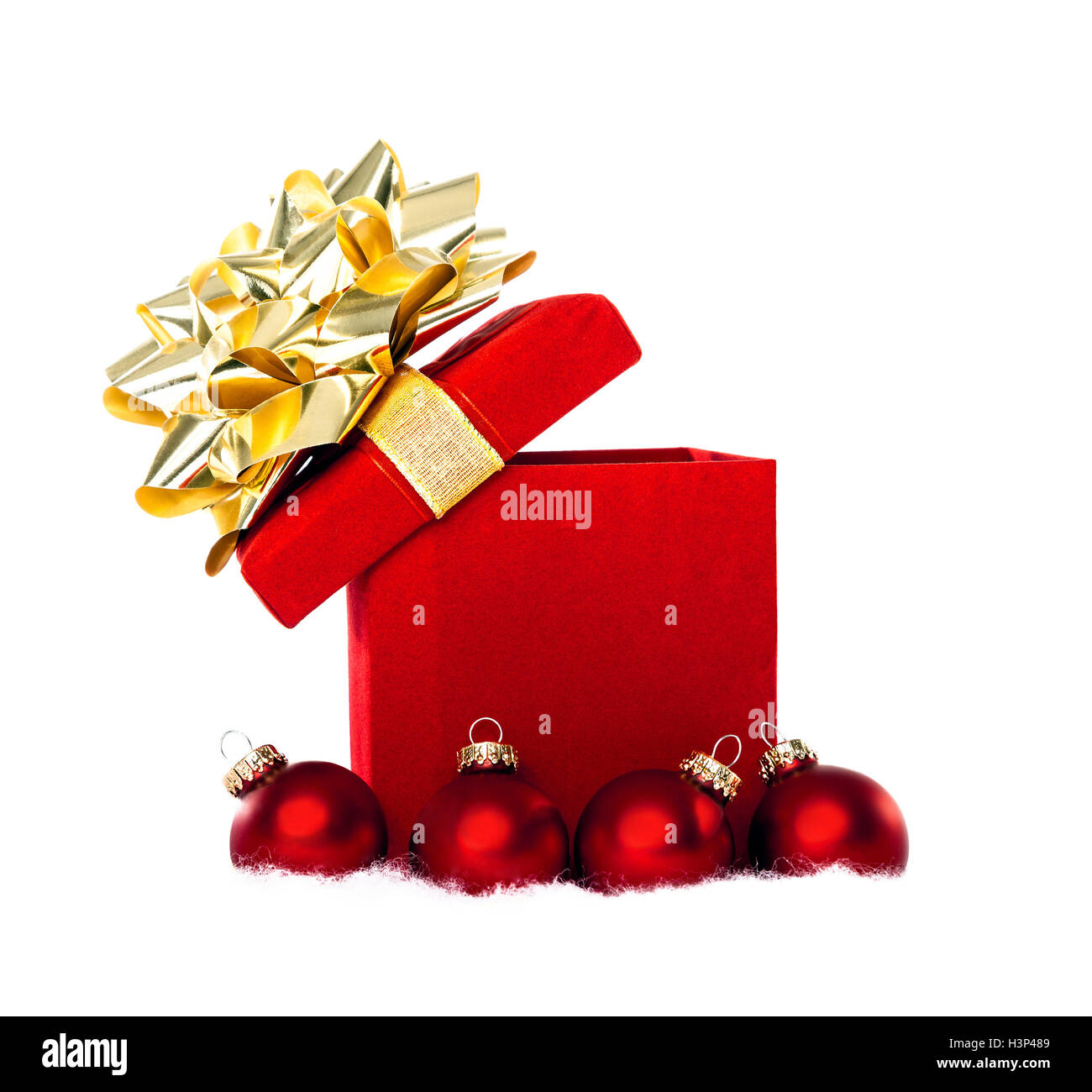 Cadeaux de Noël rouge avec ruban d'or entourée d'ornements babiole rouge sur un fond blanc. Banque D'Images