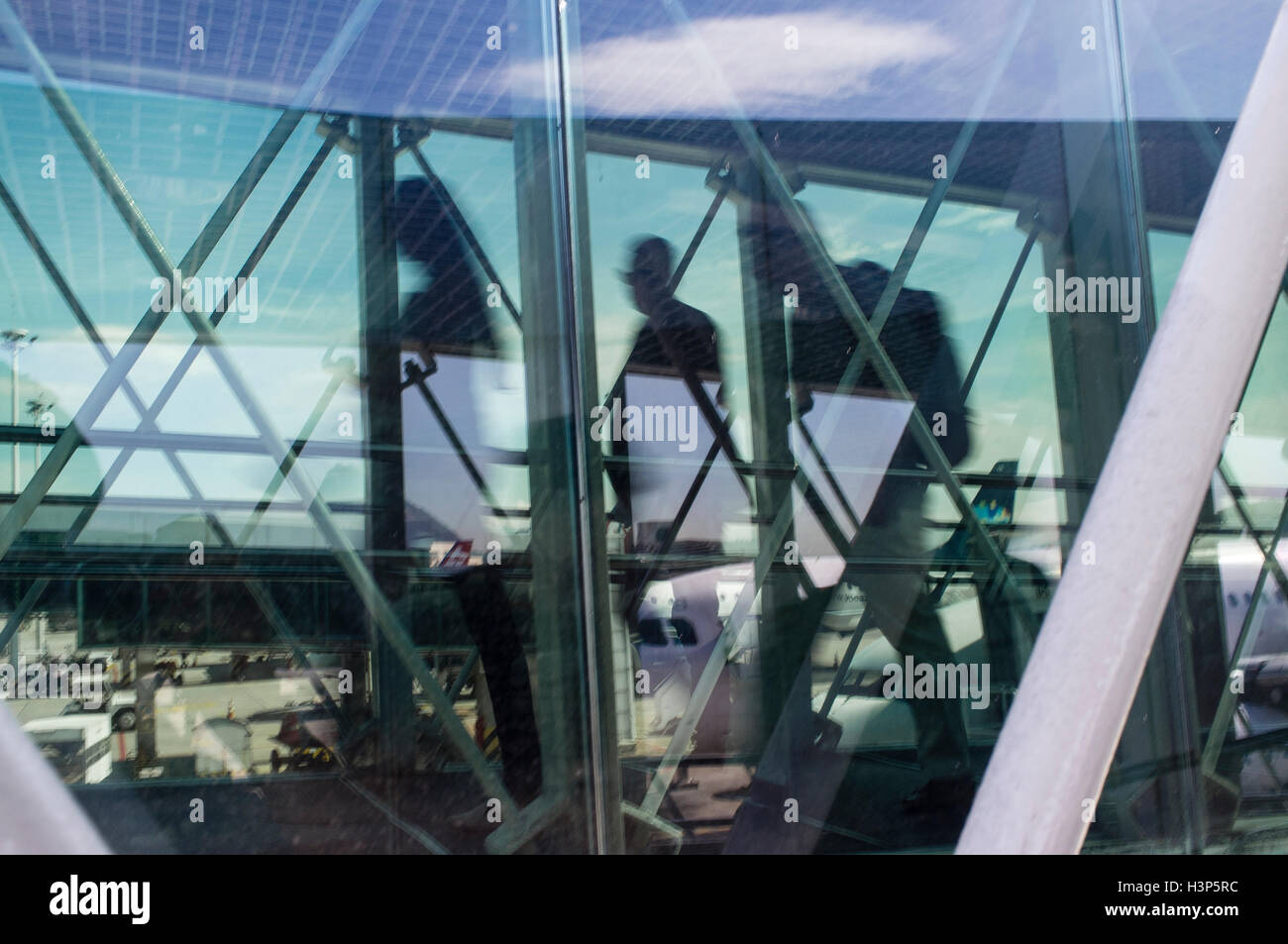 Les passagers à pied à travers une passerelle sur le chemin de l'avion à l'aéroport. Banque D'Images