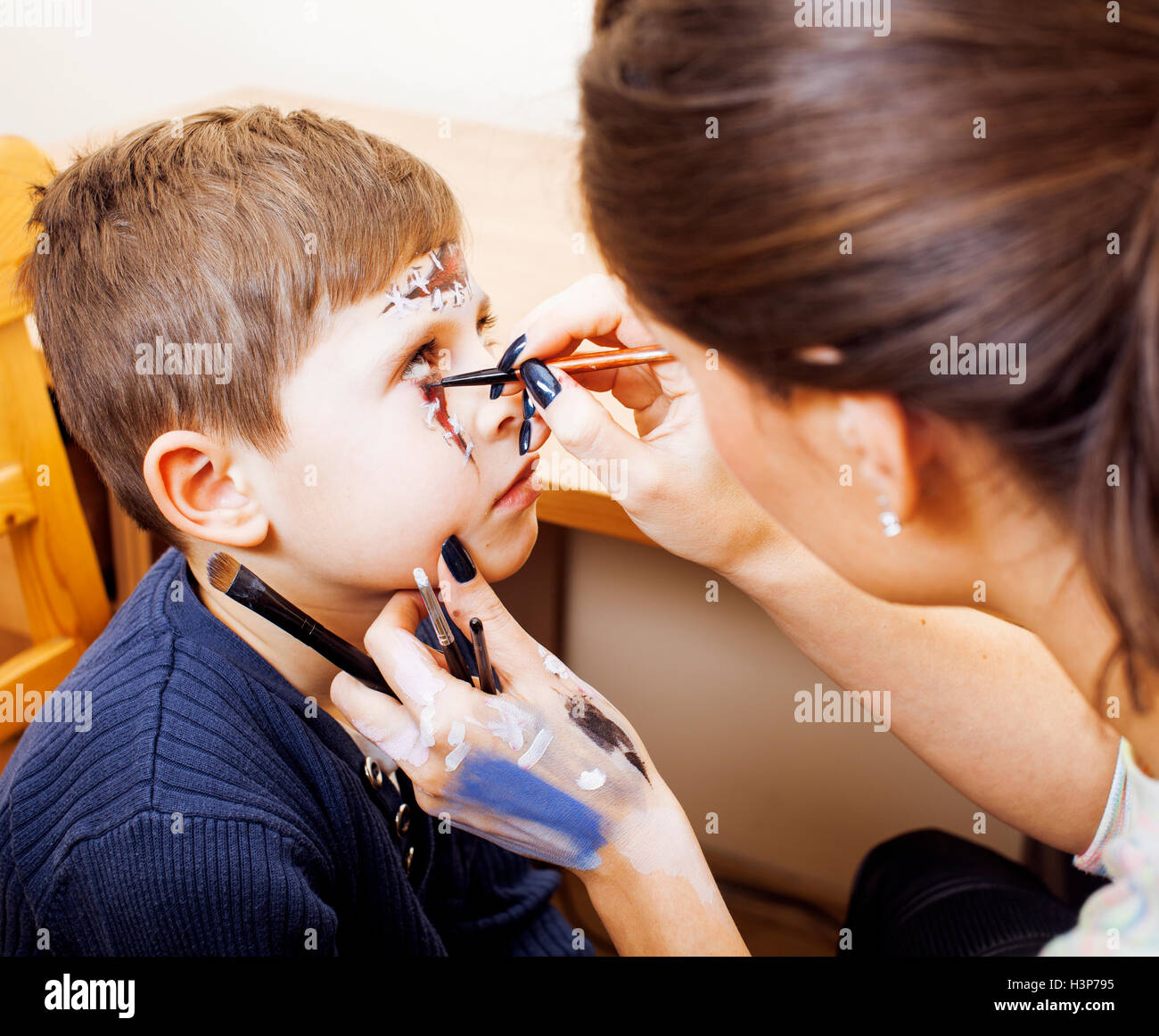 Mignon petit enfant faisant facepaint sur anniversaire, Apocalypse zombie, halloween concept préparation facepainting Banque D'Images