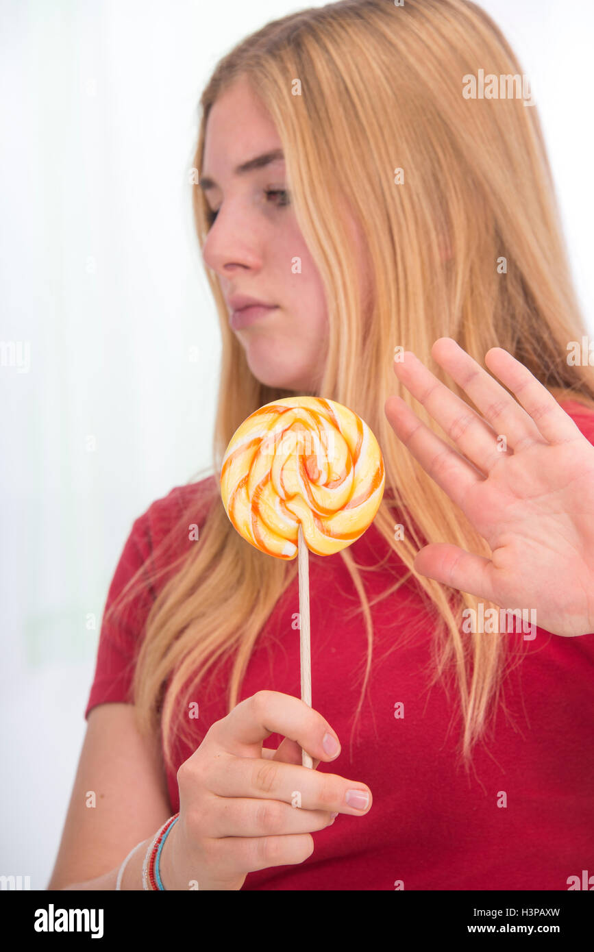 Parution du modèle. Adolescente avec lolly pop, holding hand out. Banque D'Images