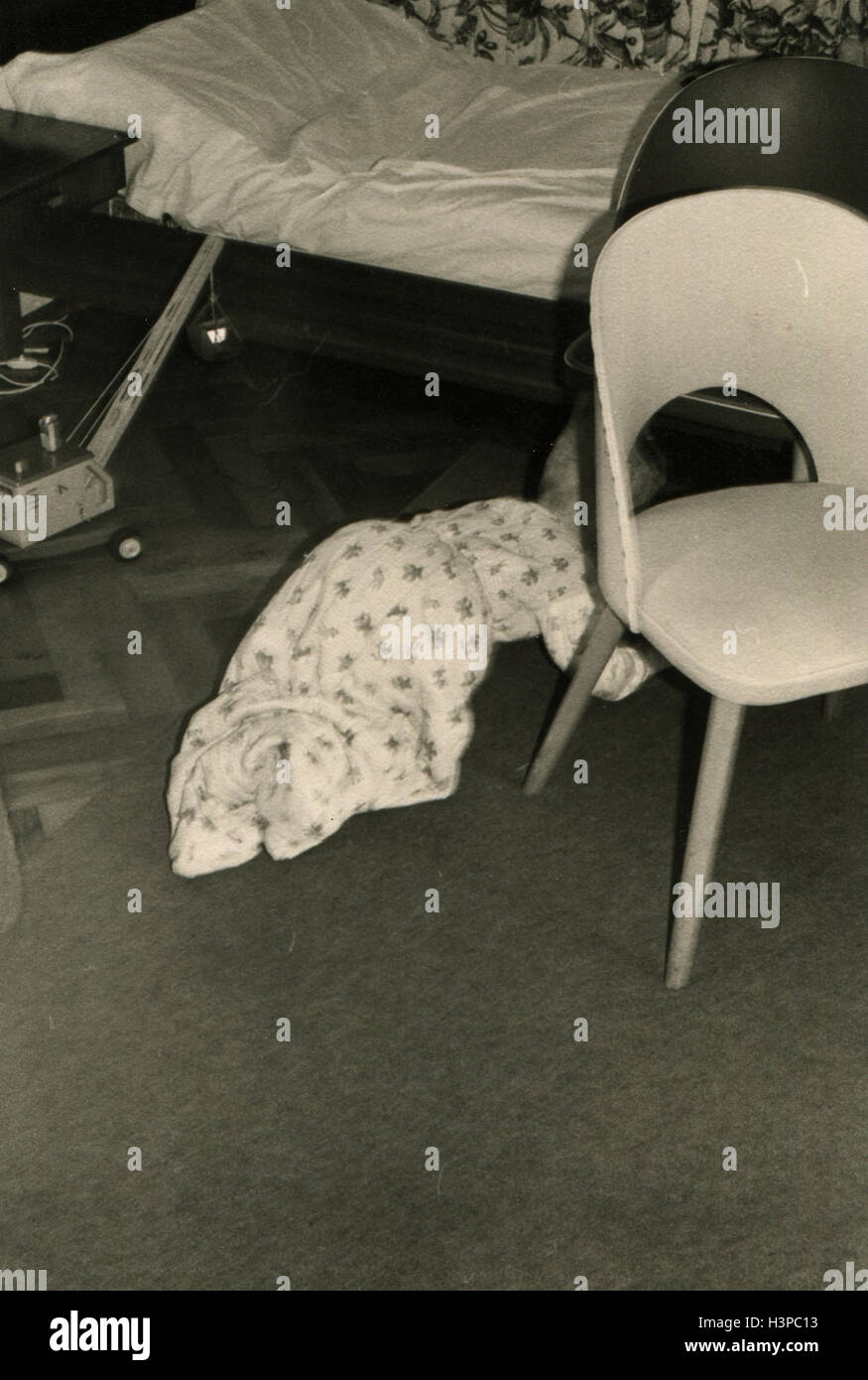 Allemagne - circa 1960 : petit bébé à quatre pattes ramper sous le lit à côté de la présidence Banque D'Images