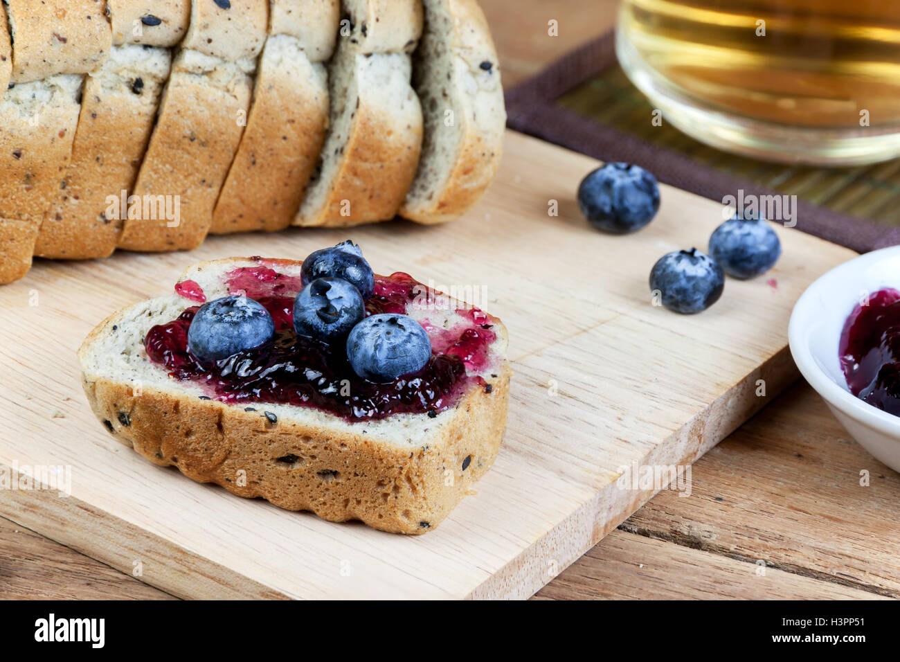 Sésame noir garniture végétarienne pain confiture de bleuets et de manger frais avec du thé chaud. Banque D'Images