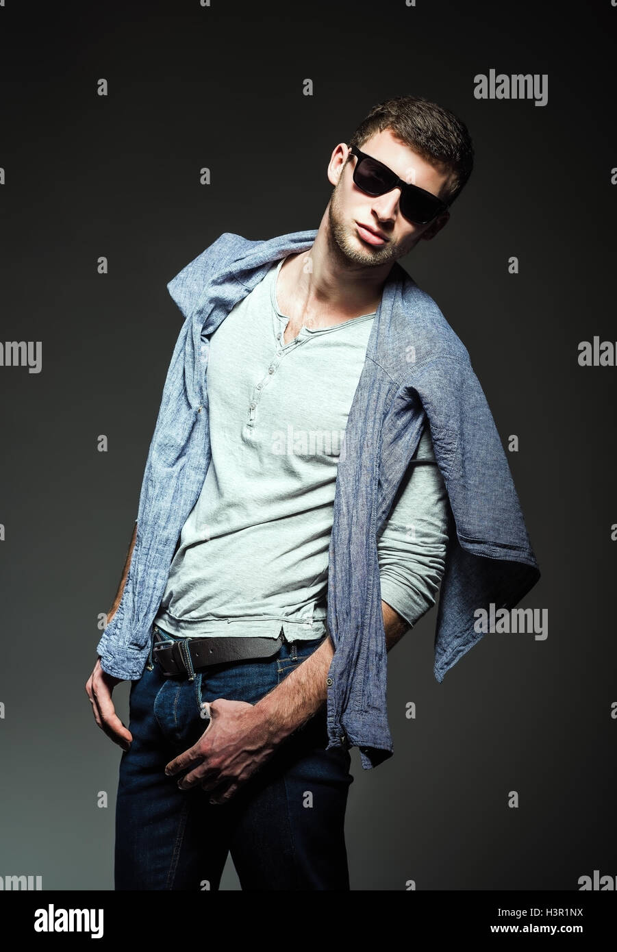 Fashion Studio shot : beau jeune homme portant des jeans, shirt et lunettes Banque D'Images