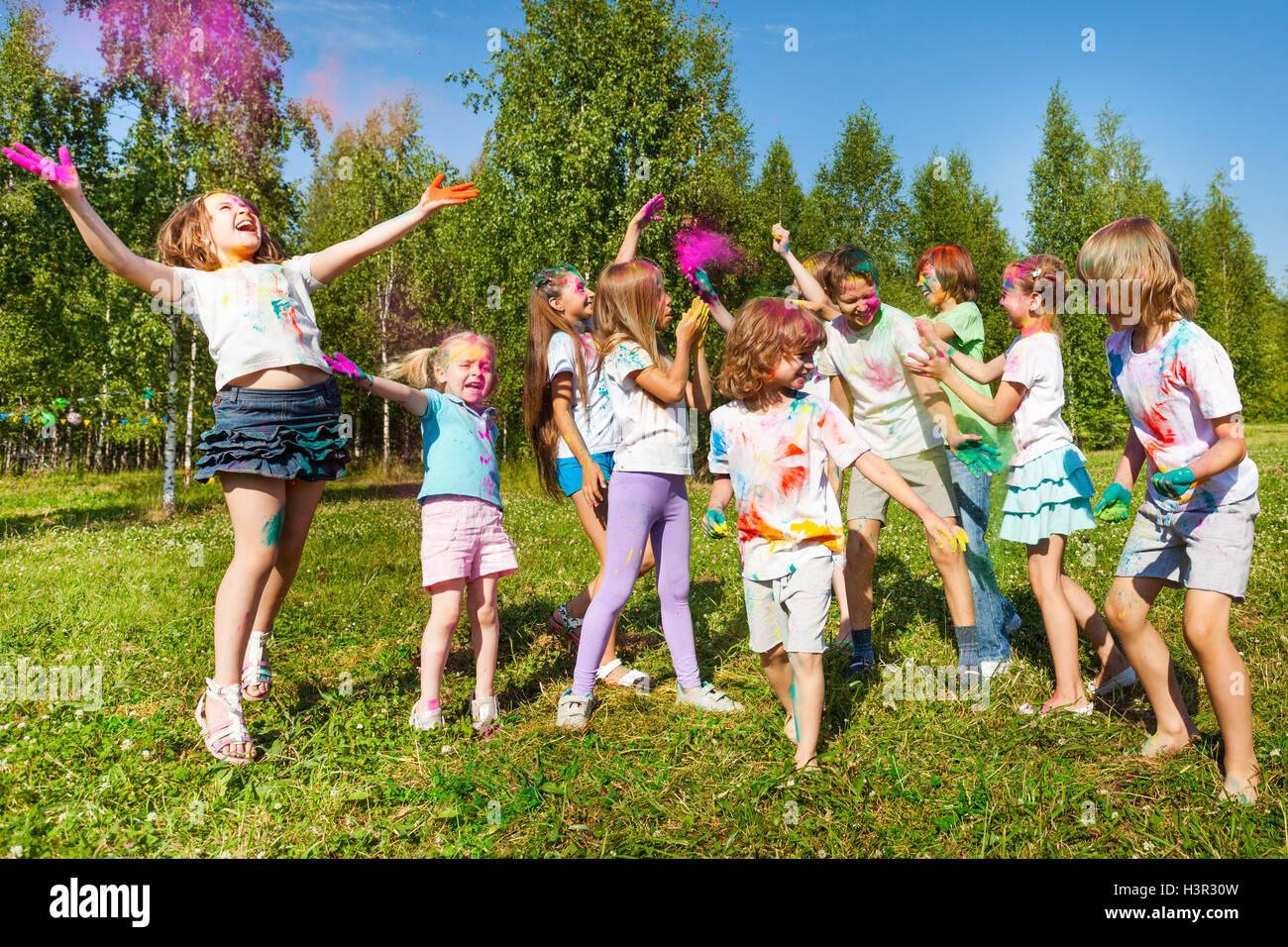 Lumineux et joyeux des enfants qui jouent avec de la poudre de couleur Banque D'Images