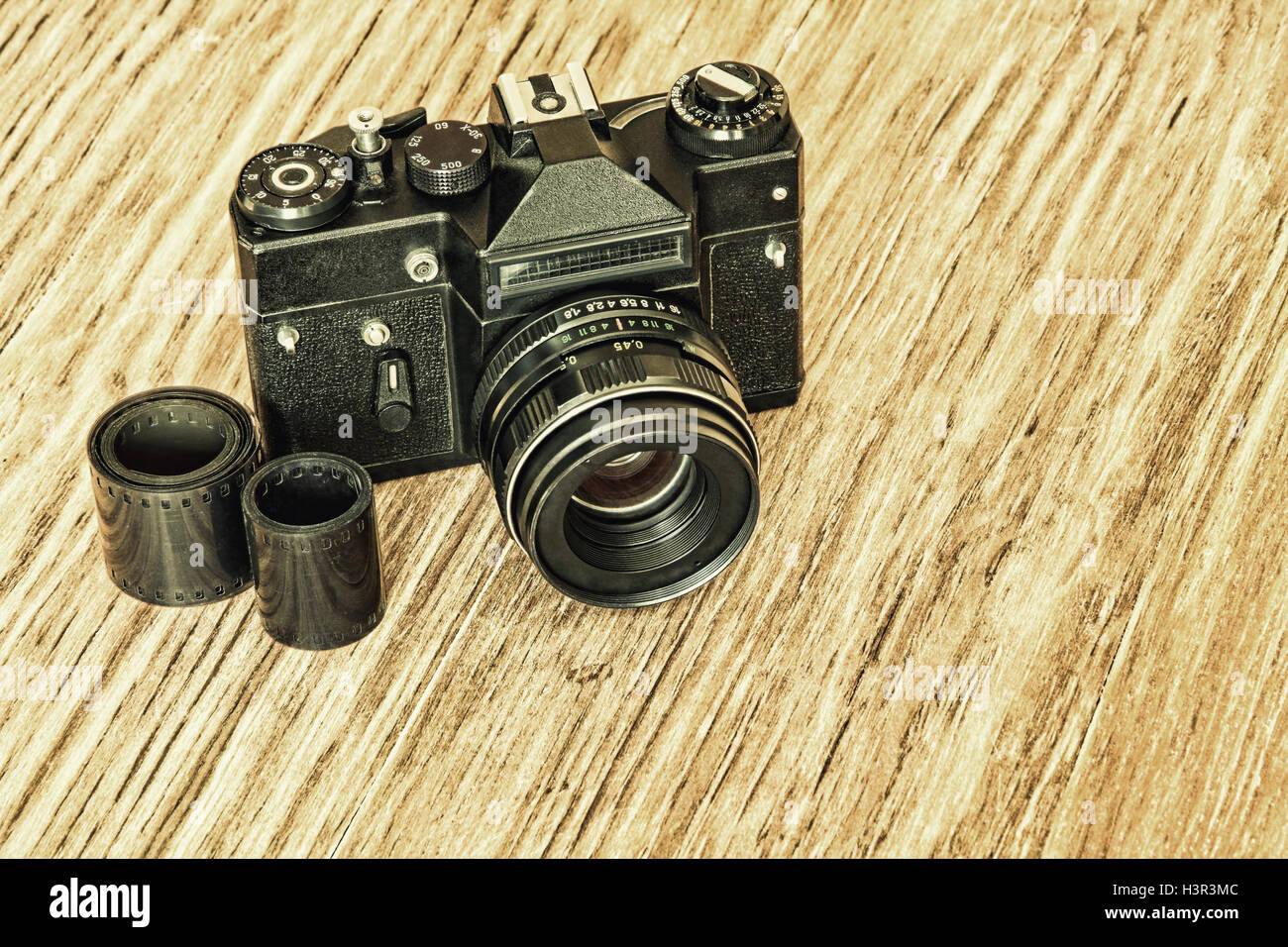 Ancienne rétro photo caméra film et bande de négatifs sur table en bois. Banque D'Images