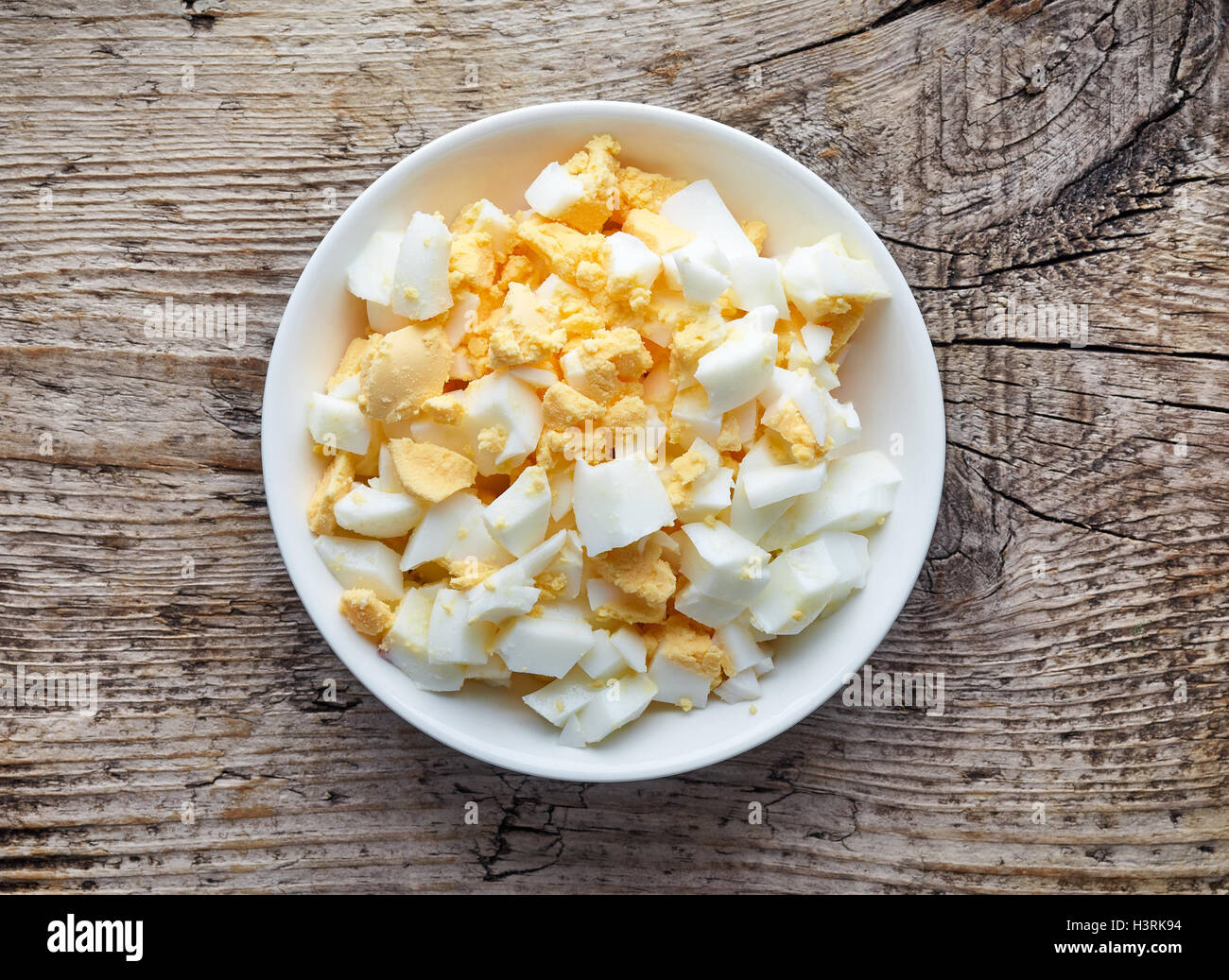 Bol blanc d'oeuf dur haché sur table en bois, vue du dessus Banque D'Images