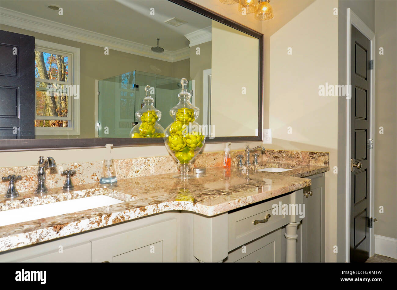 Espace salle de bain dans une nouvelle maison moderne, comptoirs de granit et les armoires blanches avec double lavabo. Banque D'Images