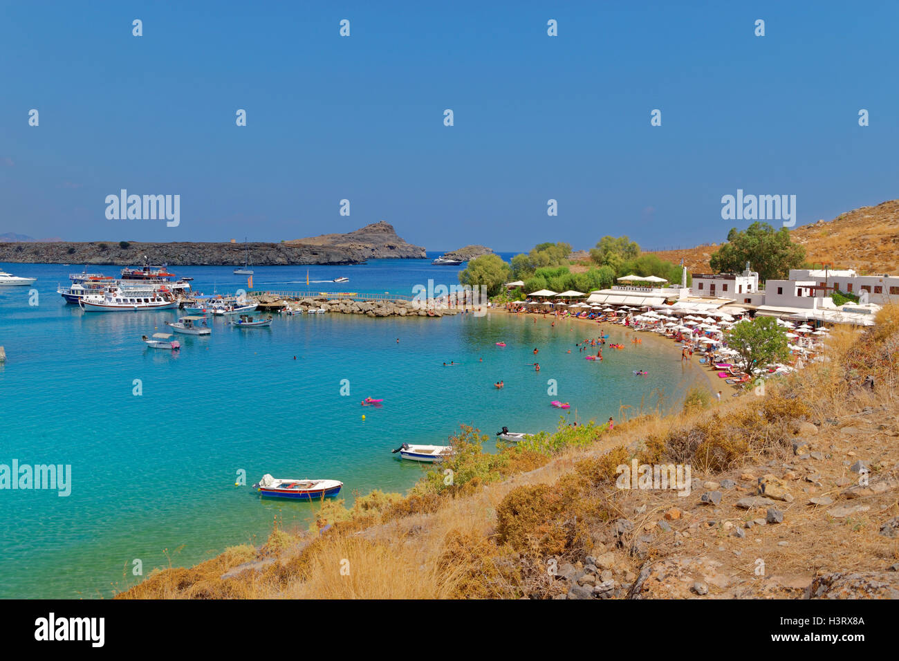 Plage de Lindos sur la côte sud-est de l'île de Rhodes, l'île du Dodécanèse, Grèce Groupe. Banque D'Images