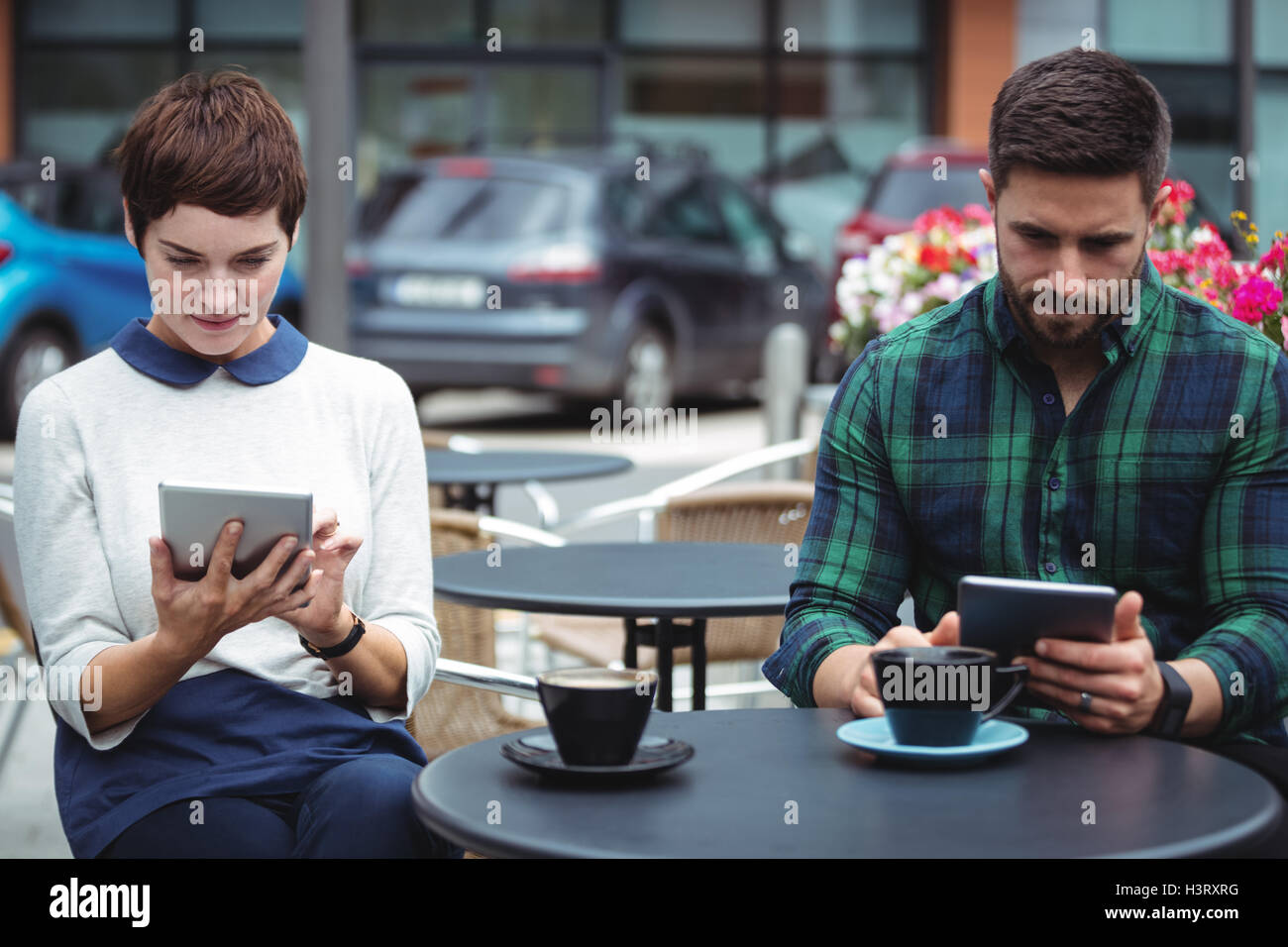 Businesspeople using digital tablet while having coffee Banque D'Images