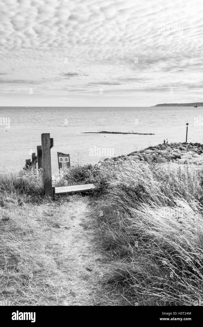 Image en noir et blanc d'étapes jusqu'à la plage sur la côte sud-ouest de la baie de Ringstead Chemin, Dorset, UK, Portland Bill dans la distance Banque D'Images