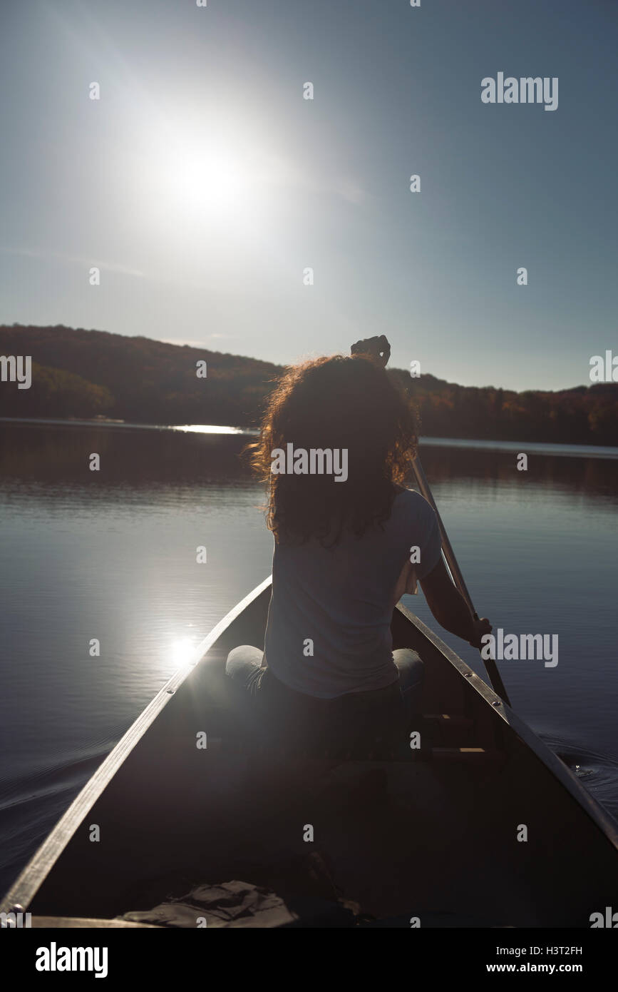 Jeune femme canoë sur un lac à l'automne. Le parc provincial Arrowhead, Muskoka, Ontario, Canada. Banque D'Images