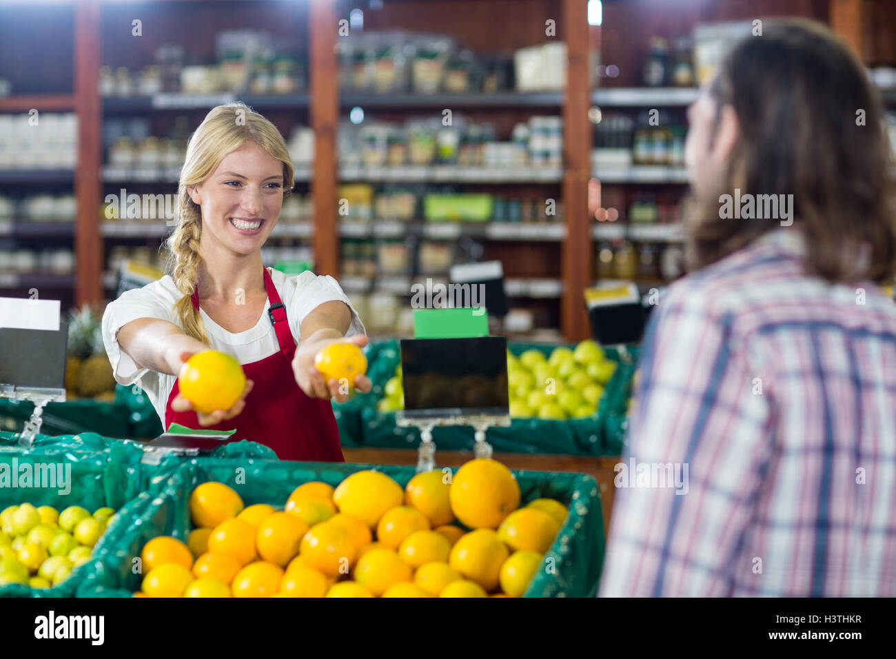 Sourire du personnel aidant un homme avec l'épicerie Banque D'Images