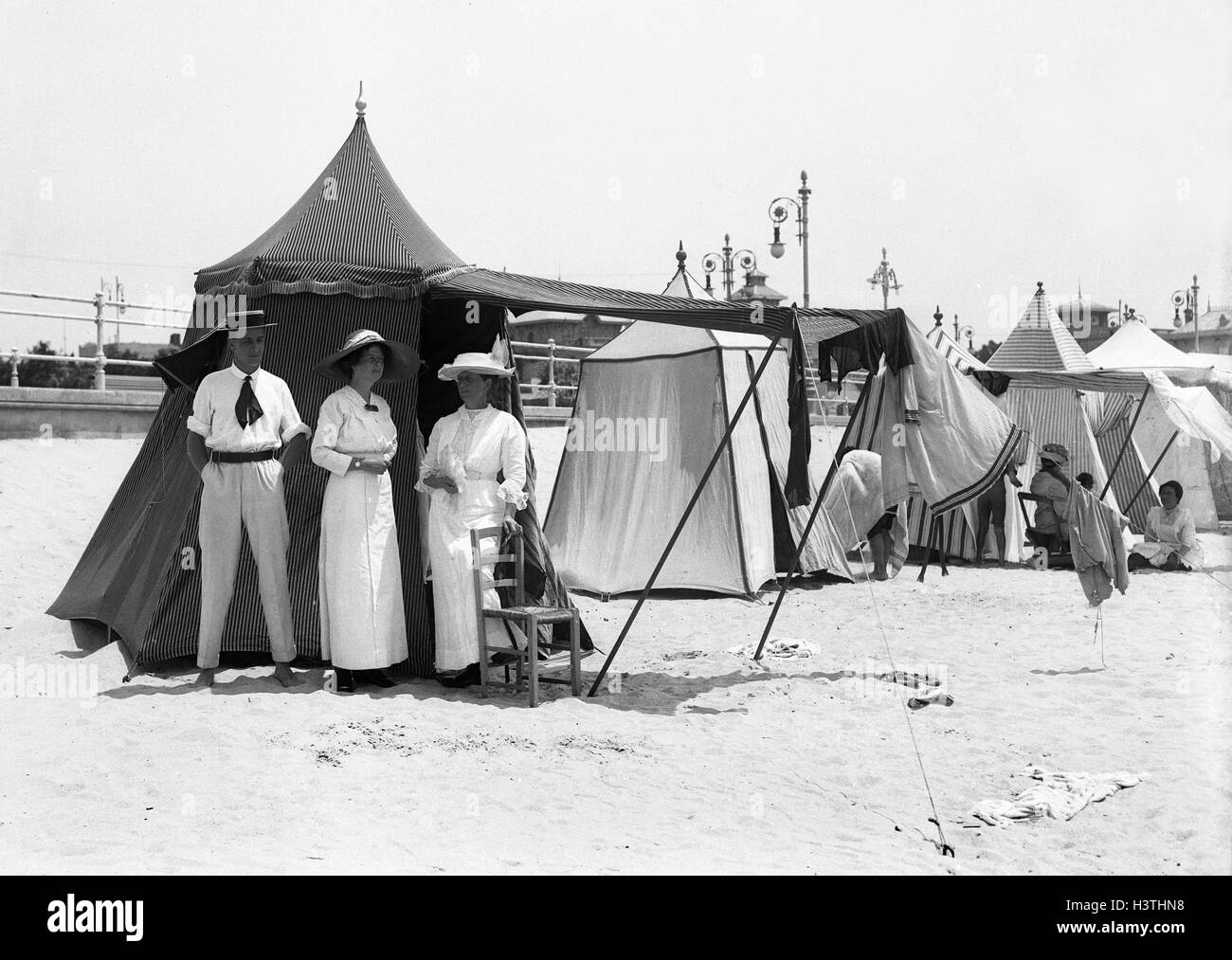 Des gens à la mode avec des tentes de plage à Deauville station balnéaire en Normandie France 1912 plage de deauville Banque D'Images