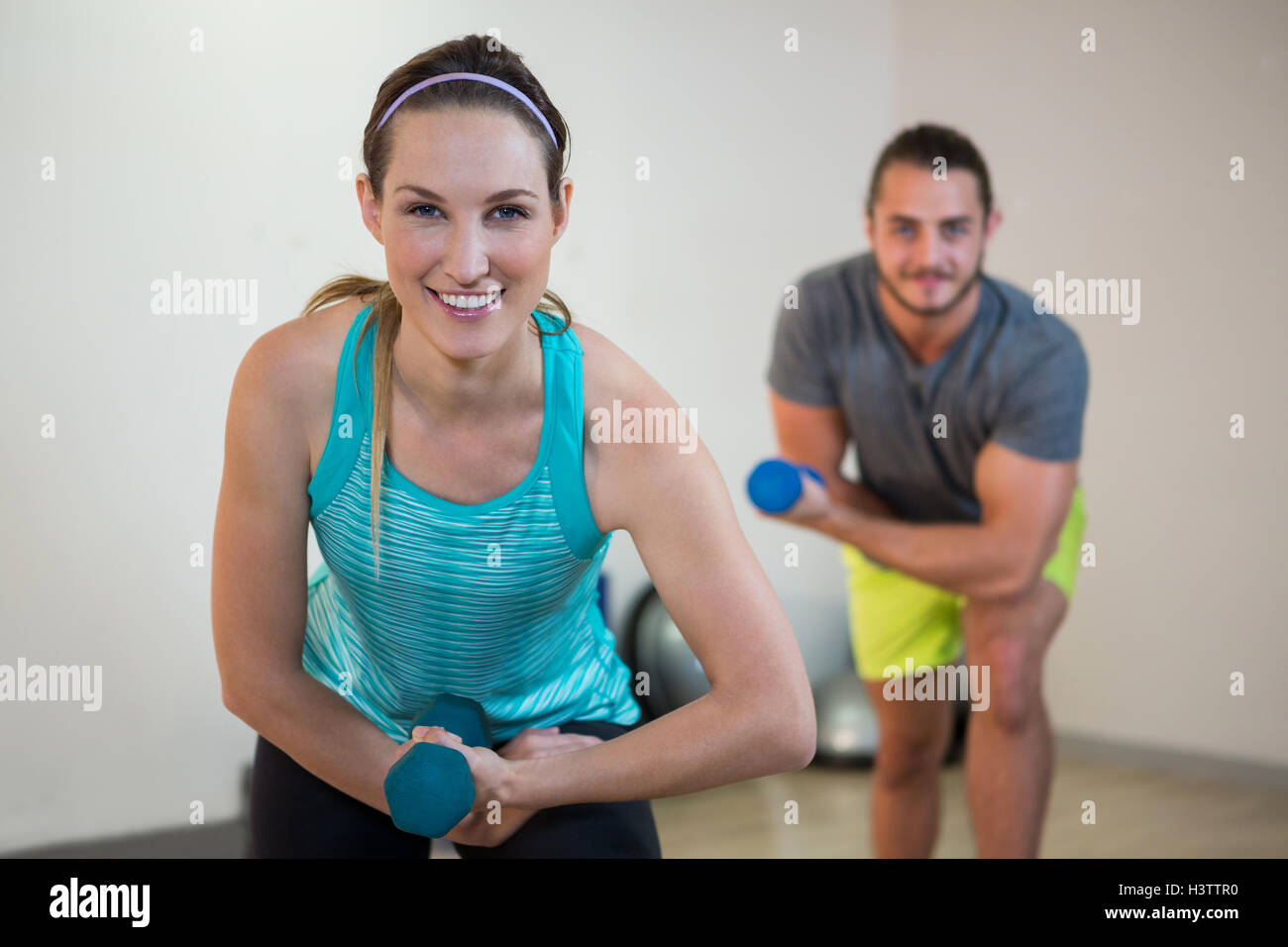 Portrait de l'homme et de la femme faisant l'exercice aérobie avec haltère Banque D'Images