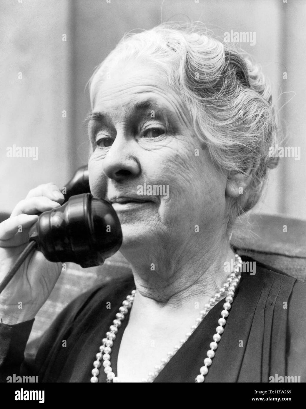 Années 1930 Années 1940 vieille femme SUR LE TÉLÉPHONE DE LA TÊTE ET DES ÉPAULES les cheveux gris PERLES LOOKING AT CAMERA Banque D'Images