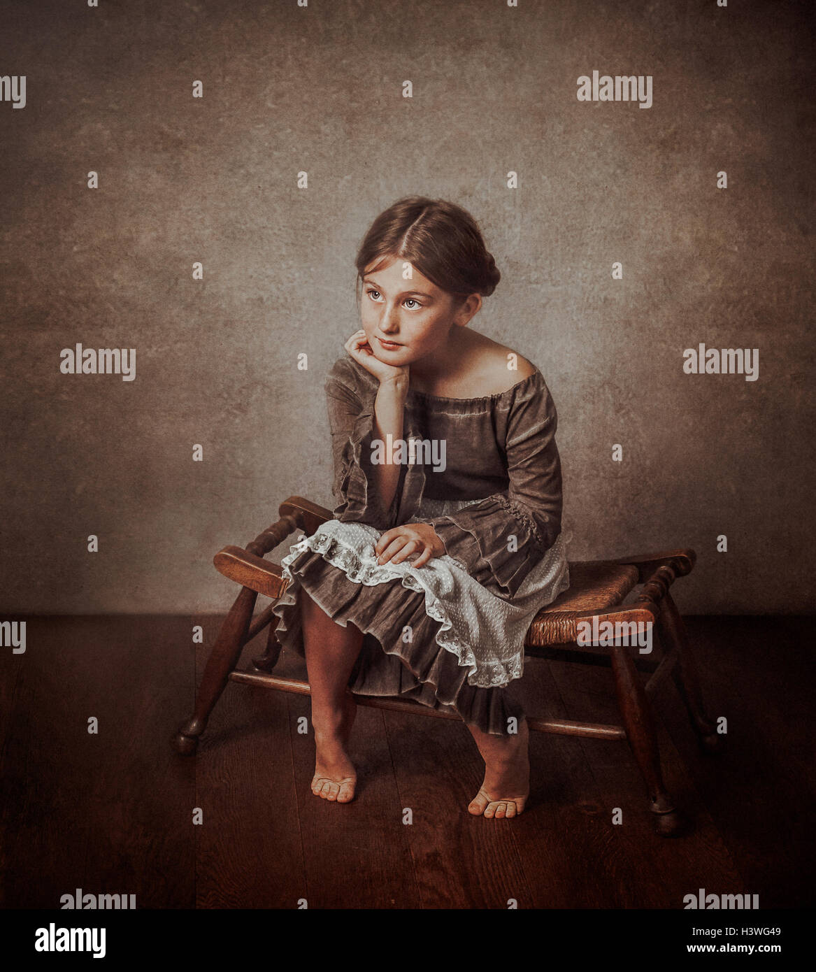 Portrait de jeune fille assise sur un tabouret Banque D'Images