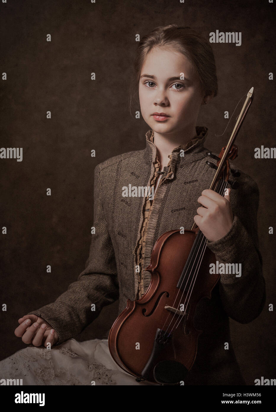 Portrait d'une fille assise avec un violon Banque D'Images