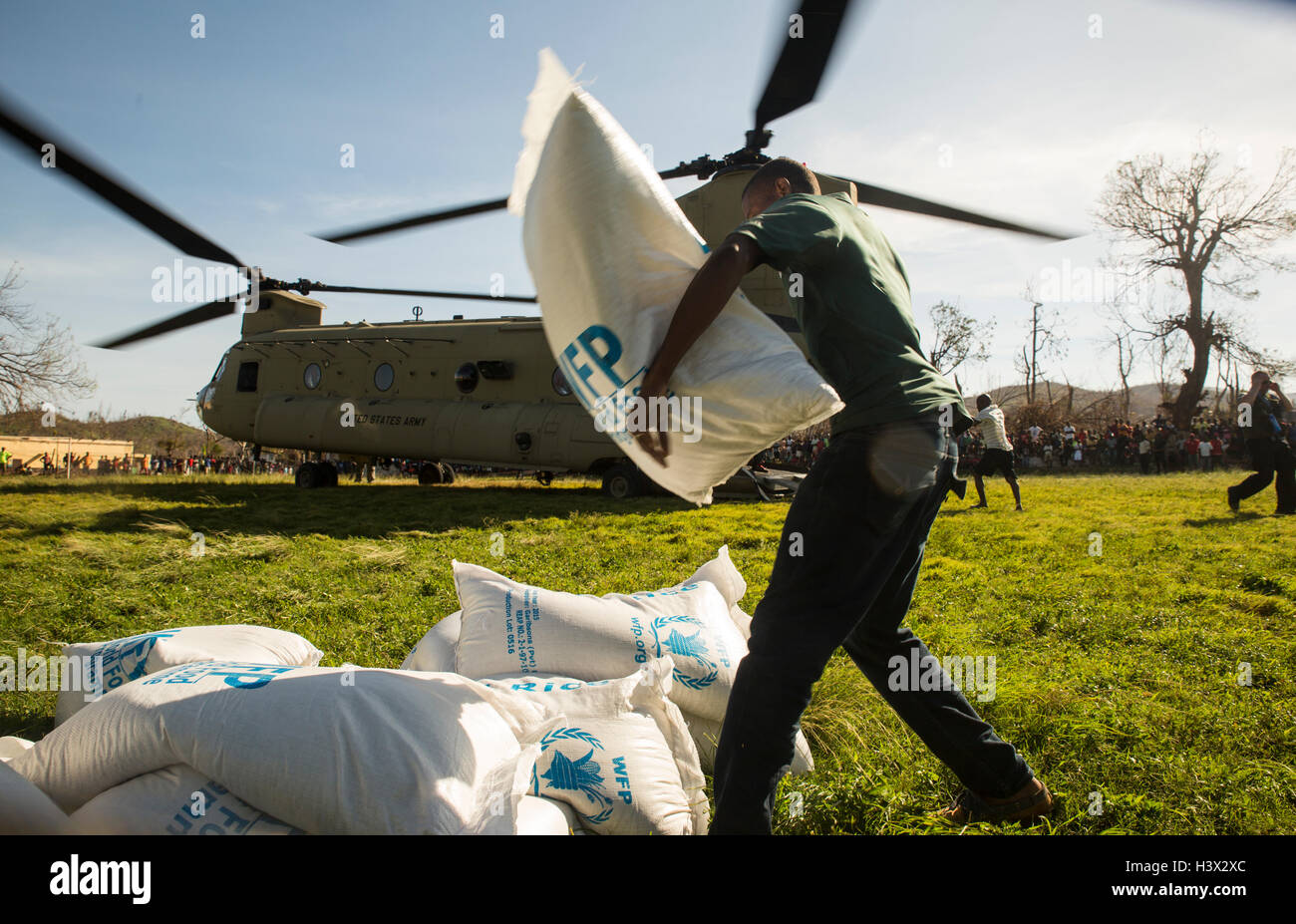 Les haïtiens se précipiter pour aider à décharger les fournitures par des Marines américains pour aider les personnes touchées par l'Ouragan Matthew 11 octobre 2016 à Dame Marie, en Haïti. L'ouragan Matthew a frappé Haïti, avec des vents de plus de 140-mph tuant 500 personnes et causant de lourds dommages. Banque D'Images