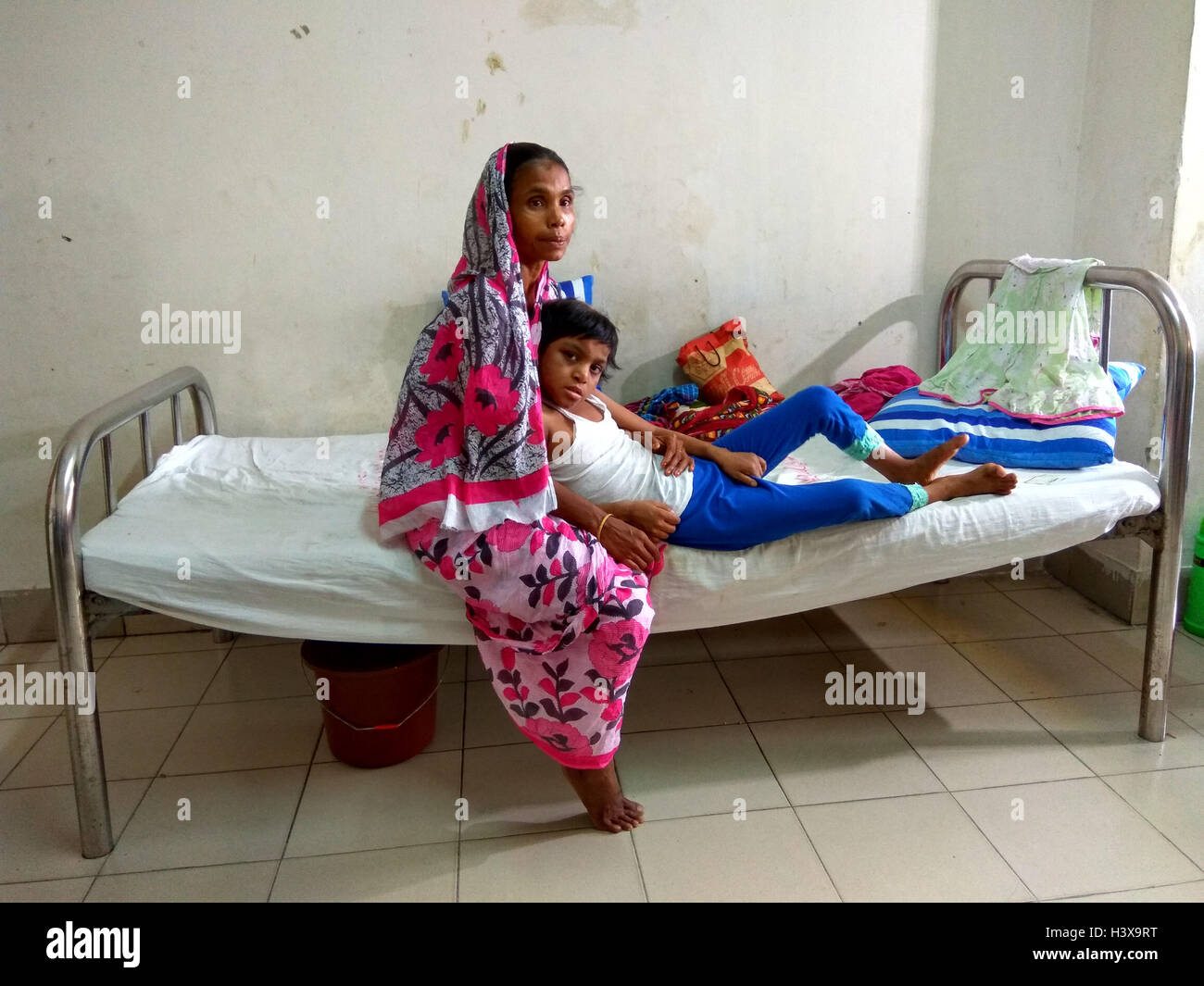 Dhaka 02 octobre 2016. Une femme montrant les cicatrices sur le corps de sa fille de 7 ans, à l'Jannat dirigé de de Dhaka Medical College Hospital récemment. Jannat, qui a travaillé en tant qu'enfant servante à Gazipur, près de la capitale du Bangladesh, était souvent battu son employeur, une femme au foyer. La dame a également utilisé pour brûler plusieurs parties du corps de la jeune fille avec un fer chaud et les ustensiles. Banque D'Images