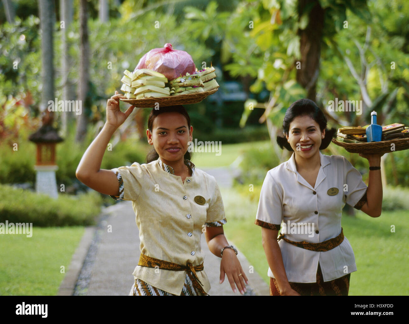 L'île de Bali, Indonésie, Bukit peninsula Badung, Nusa Dua, Bali 'Melia pour sol', installation de l'hôtel, les employés de bureau, les femmes les petites îles de la sonde, Sundainseln, Pulau Bali, hôtel 5 étoiles, le personnel de l'hôtel, employée de bureau, Indonésien, deux, de paniers, de transporter, de charger la tête, d'offrir, de pelures sacrificiel, opus, à l'extérieur de fumé Banque D'Images