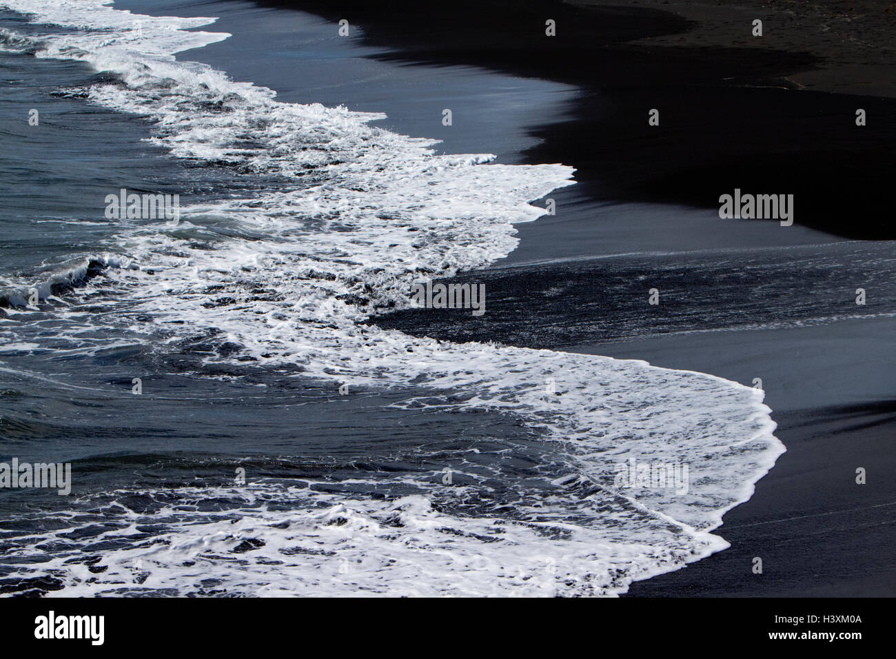 Vagues se brisant sur la plage de sable noir volcanique du sud de l'Islande bakki Banque D'Images
