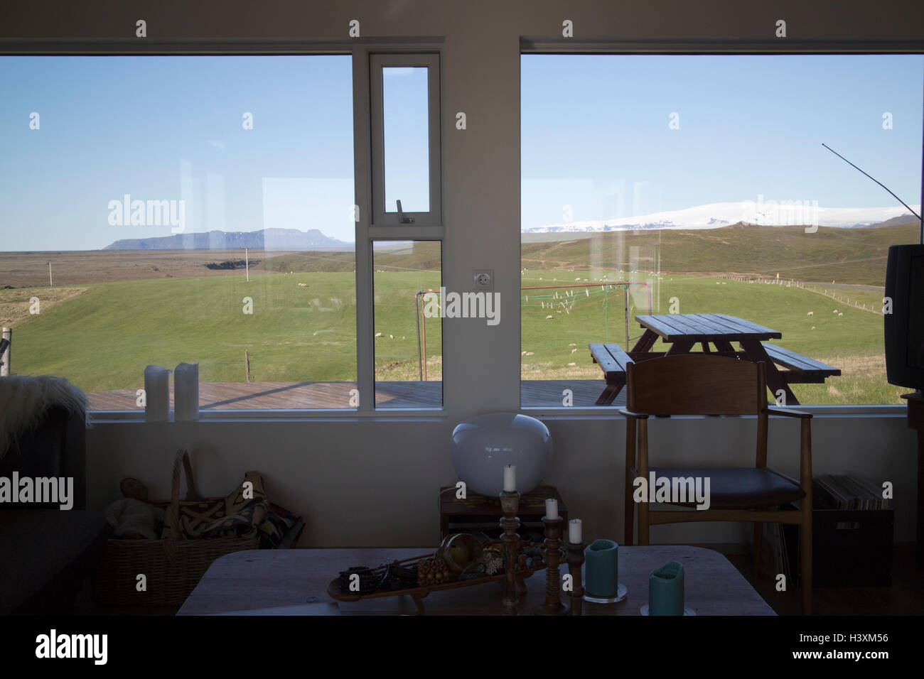 Vue sur les terres agricoles et les glaciers myrdalsjokull hors d'une fenêtre dans une maison d'hôtes en Islande Banque D'Images