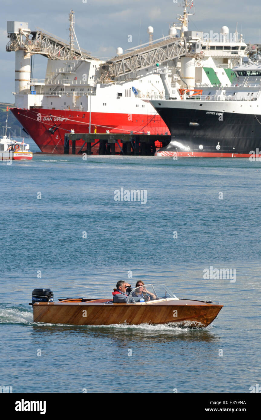 Un petit bateau traverse en face de Falmouth docks Banque D'Images