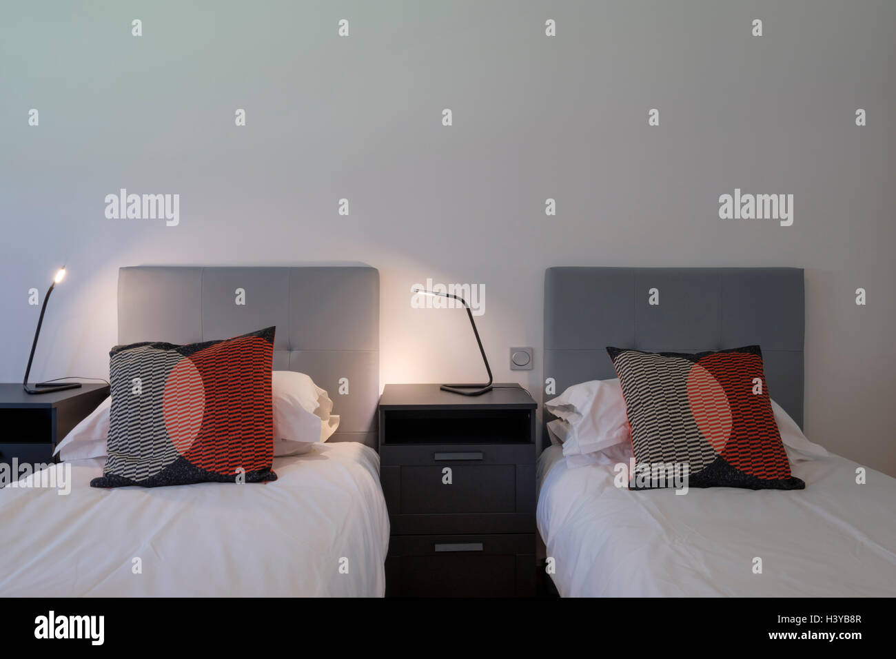 Deux lits simples côte à côte avec une table de nuit en bois sombre Photo  Stock - Alamy