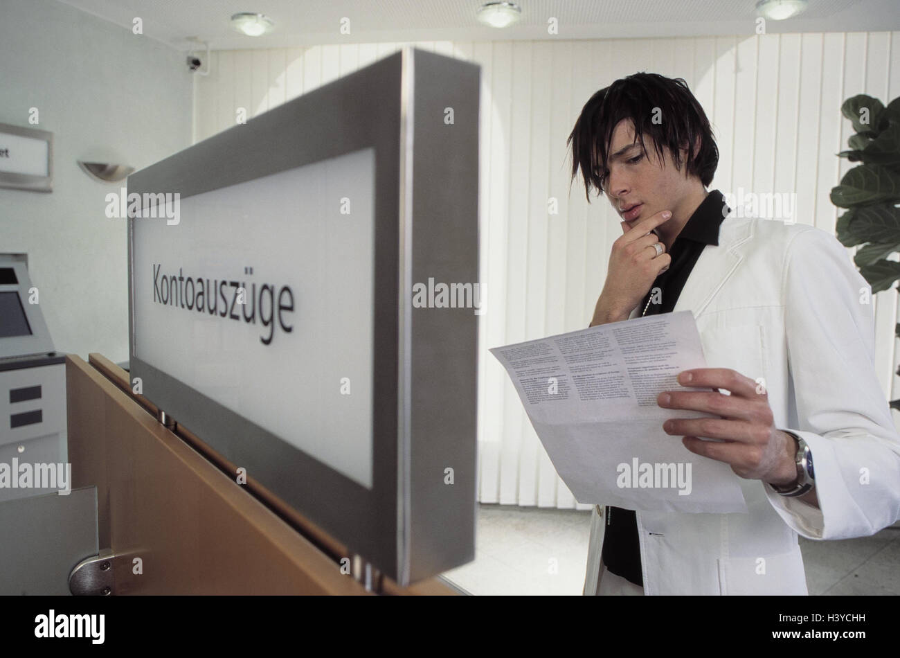 Banque mondiale, l'homme, des relevés bancaires, chèque, jouer du visage, institut de crédit, horrifie sur solde au crédit, d'interroger, d'attention, soigneusement, d'informer, de l'information, insatisfait, mécontentement, lire, surprises, le secret bancaire, suivi de compte, la divulgation, l'obligation t Banque D'Images