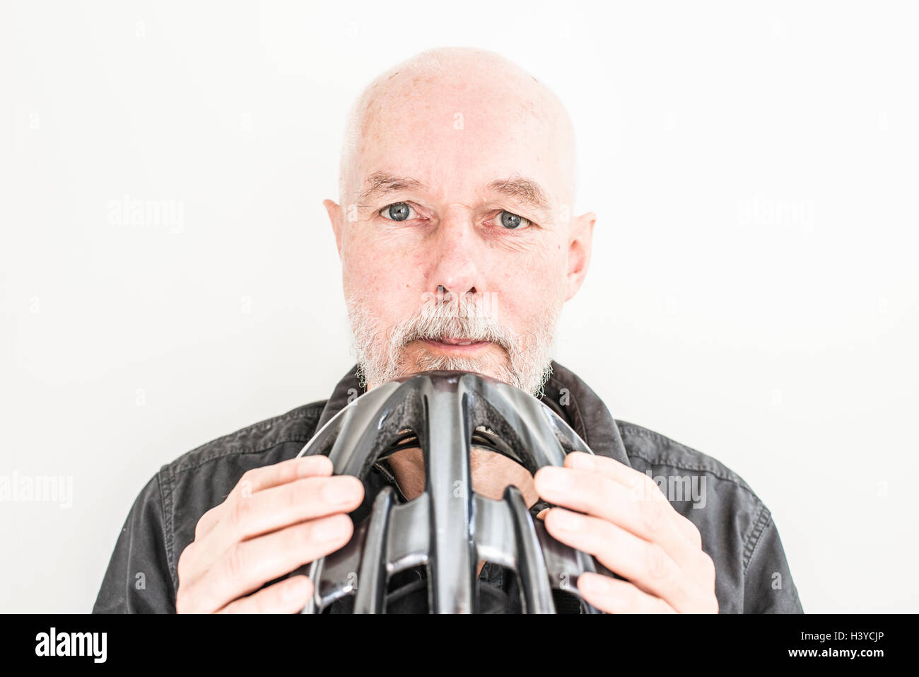 Close up of old man holding un casque de vélo. Portrait d'une personne âgée vivant une vie active avec un mode de vie sain. Banque D'Images