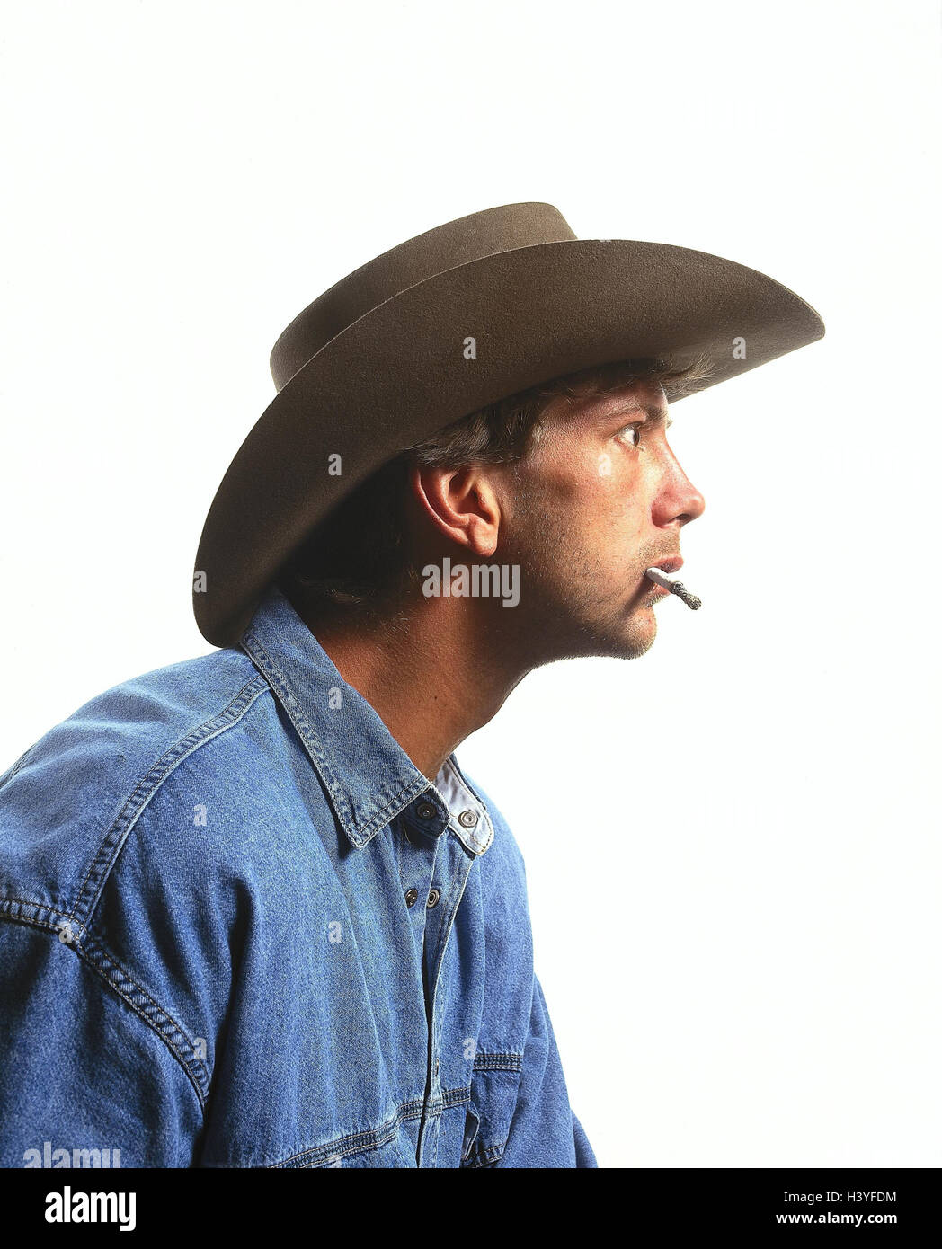 L'homme, stetson, cigarette, jouer du visage, étonnement, portrait, à l'intérieur, les jeunes, jeans, shirt, étonné, s'étonne, fascination, entrancedly, stare, près de studio, cut out, aperçu Banque D'Images
