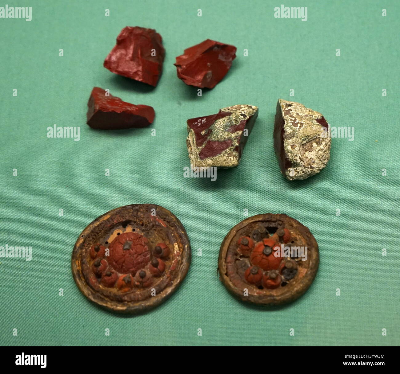 Les disques décoratifs constitués de verre opaque rouge, monté sur une plaque de bronze entouré de clous de fer. En date du 2e siècle avant J.-C. Banque D'Images