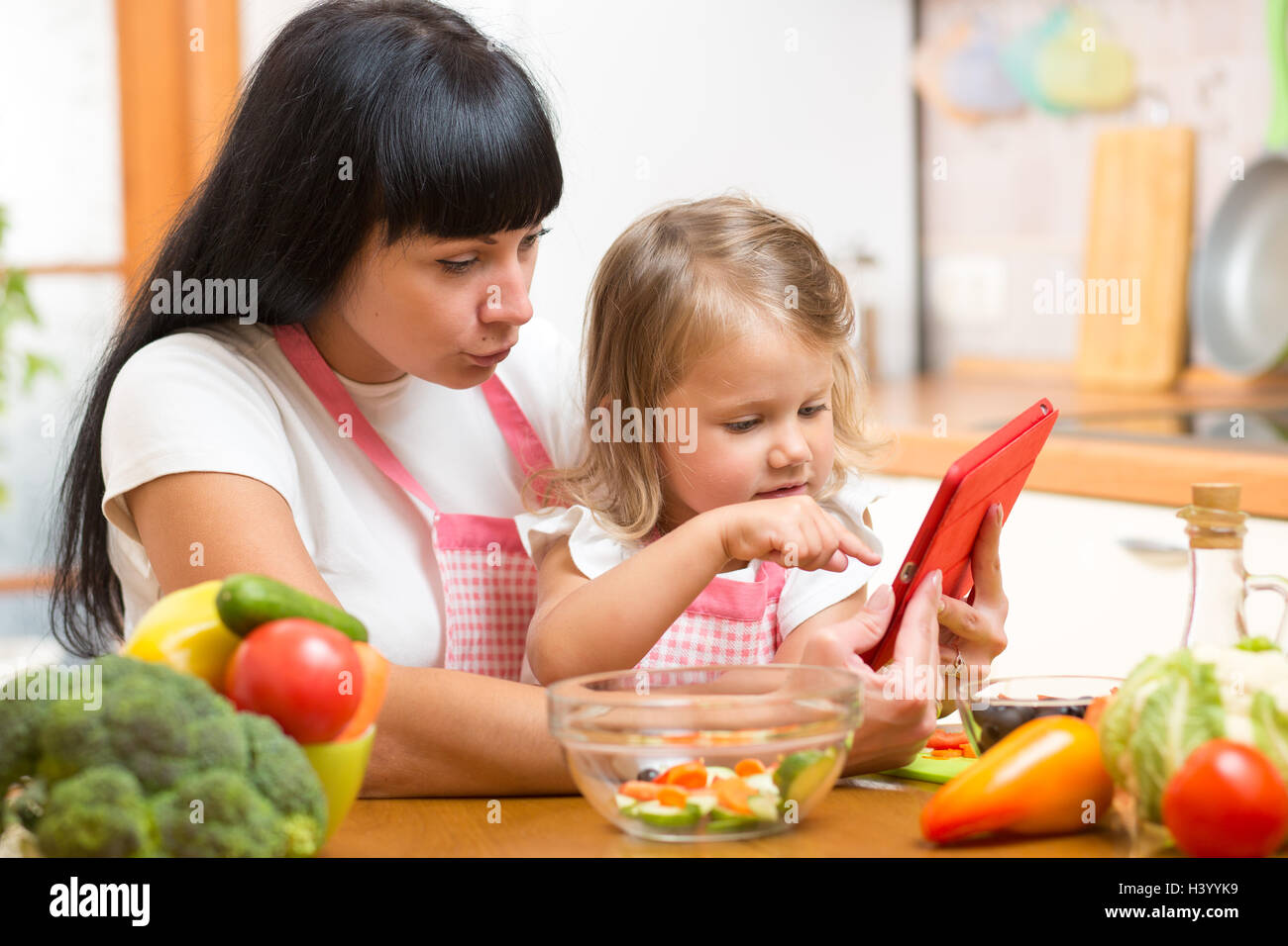 Mère et enfant fille préparer la recette de cuisine. Banque D'Images