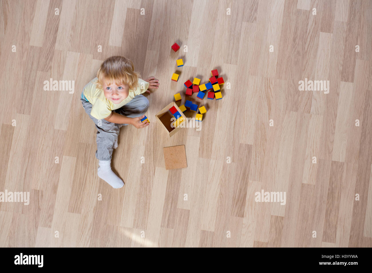 Enfant jouant avec des jouets sur le plancher haut afficher Banque D'Images