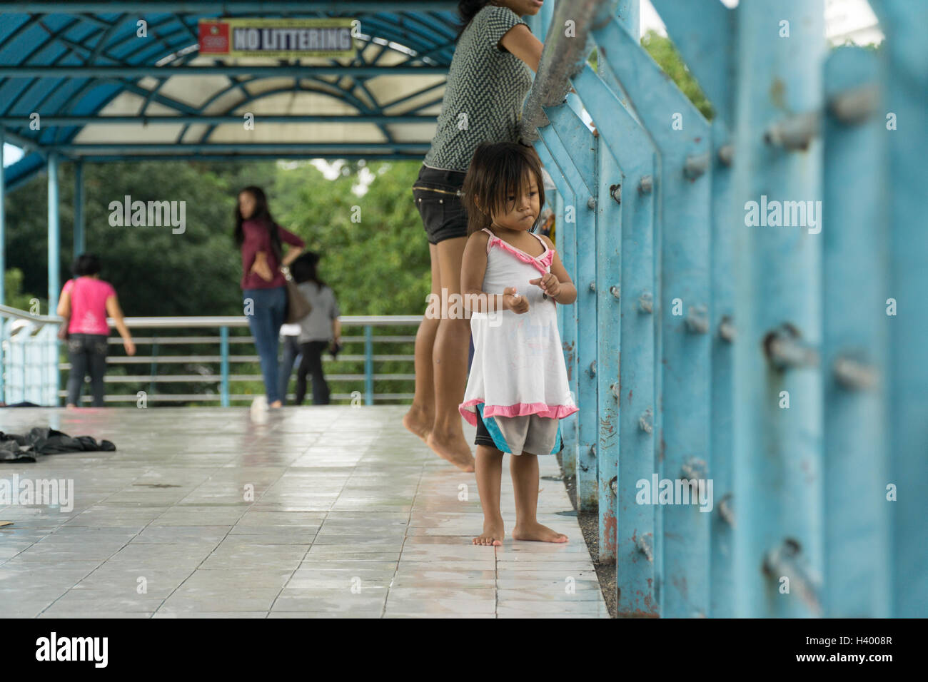 Jeune fille sans-abri dans un article une passerelle dans la ville de Cebu, Philippines Banque D'Images