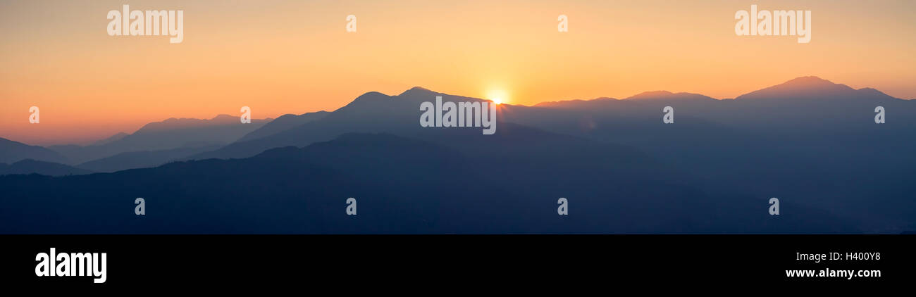 Vue panoramique sur les collines et montagnes avec brume bleue à l'heure d'or et magnifique coucher de soleil Banque D'Images