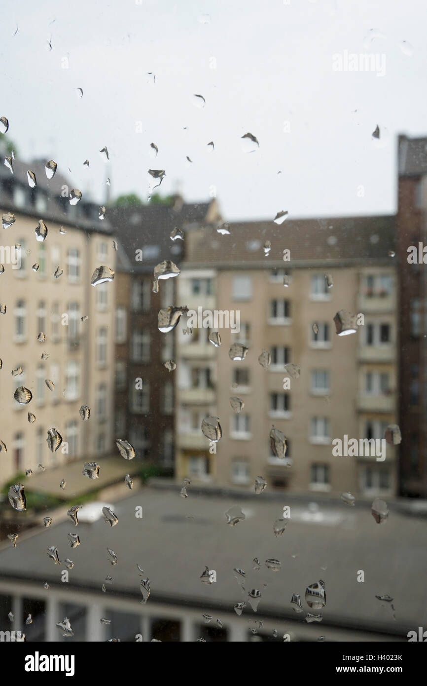 Des bâtiments contre ciel vu à travers la fenêtre de verre humide Banque D'Images