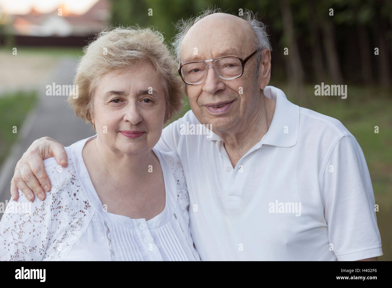 Portrait of smiling senior couple standing at park Banque D'Images