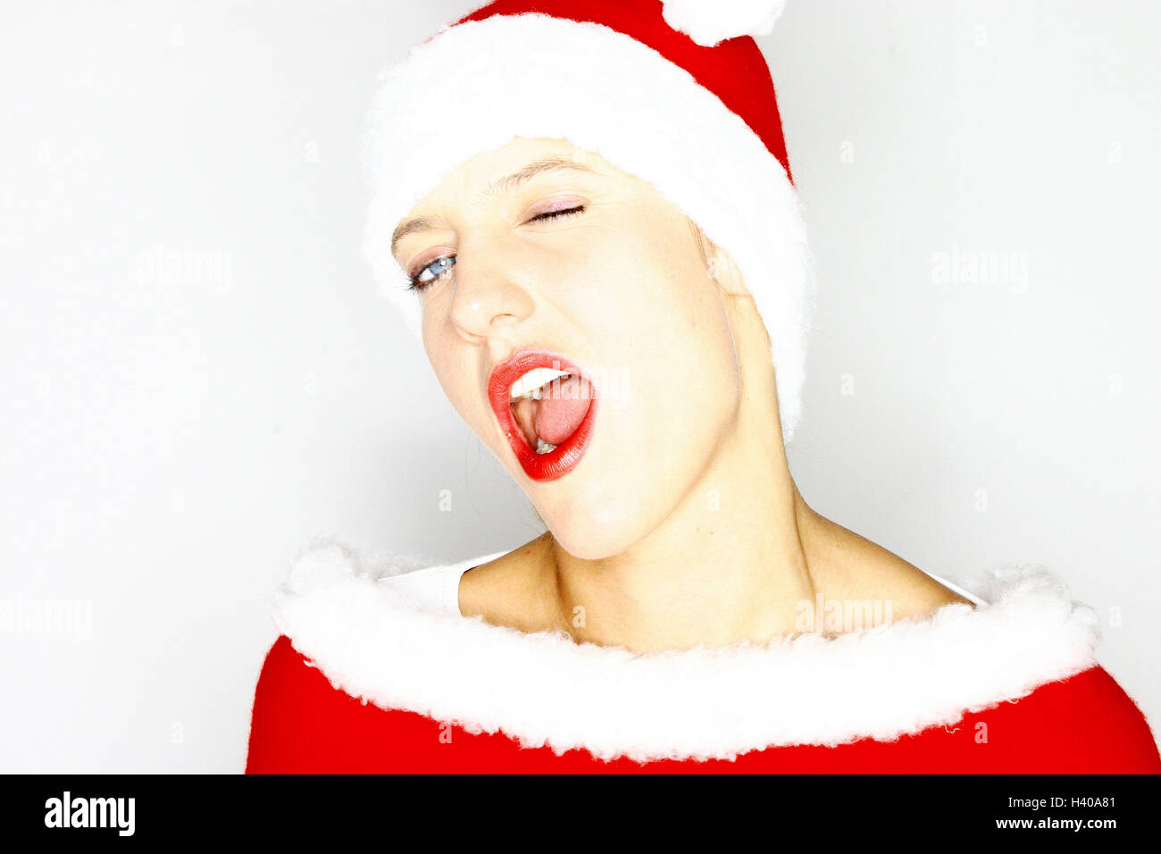 Femme, Santa's hat, jouer du visage, Wink, Wink, Nicholas portrait du père Noël, Noël, femme, femme, jeune, de 20 à 30 ans, les yeux bleus, composé, maquillage, rouge lèvres, bouche ouverte, activer, heureux, fondu, effronté, pertly, stimulant, d'attirer, Pac, PAC, a souligné qu'il Banque D'Images