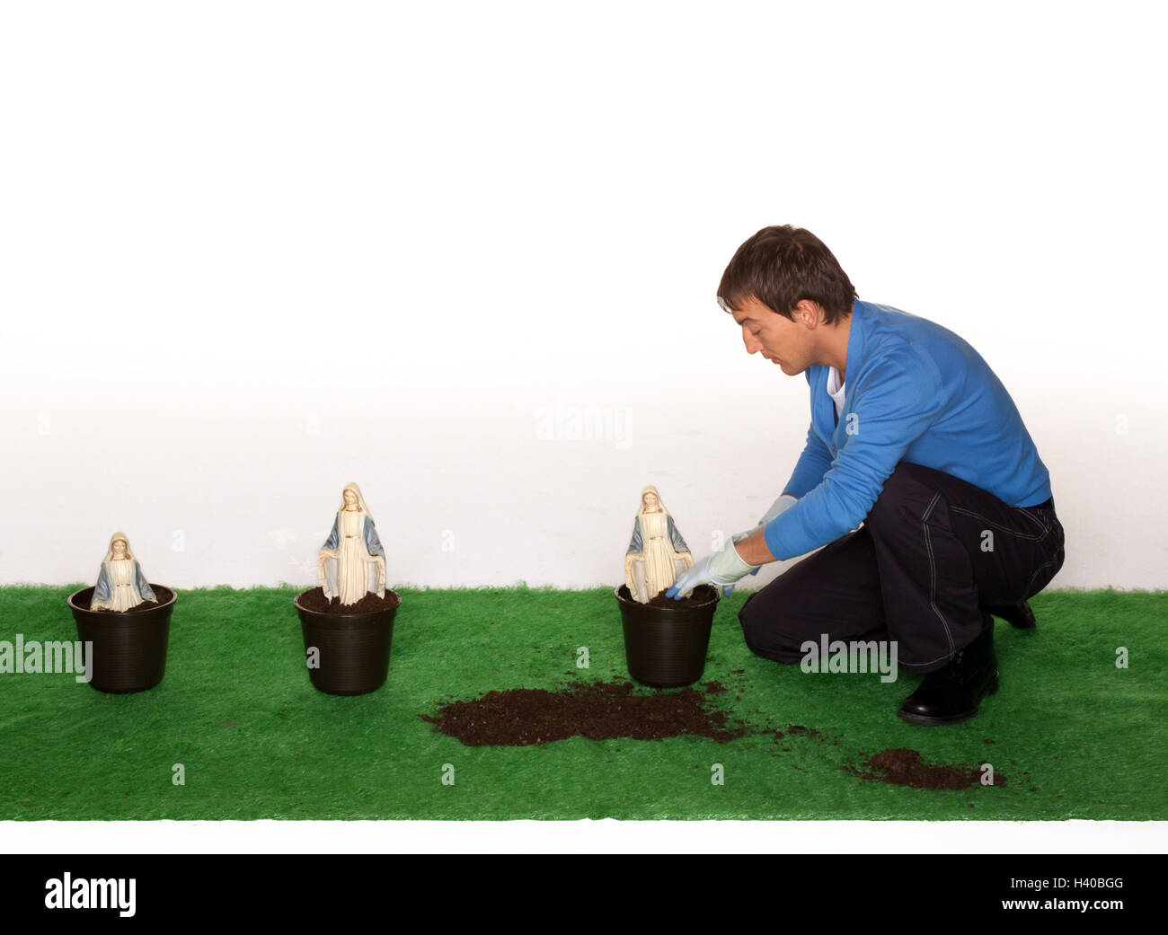 L'homme, Madonna, chiffres, eintopfen les gazons de l'art, s'agenouiller, implant, de 20 à 30 ans, affectueusement, soigneusement, hobby, jardinage, jardinier, jardinier amateur, les figures d'un saint, Marien, icône, la fertilité, la croissance, la foi, la religion, madones, studio, conception, le crankiness Banque D'Images