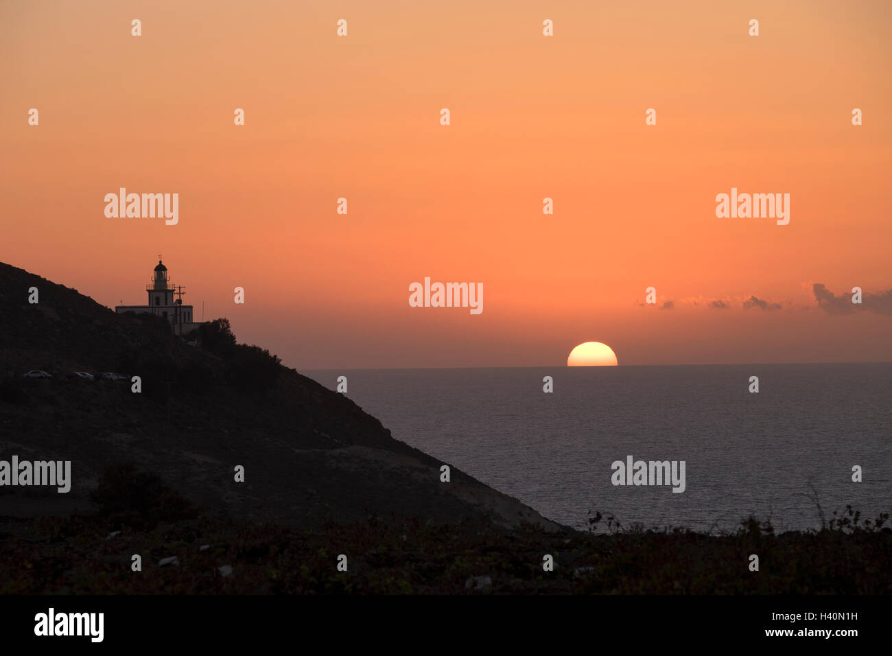 Coucher du soleil au phare sur la pointe ouest de l'île de Santorin, en Grèce. Banque D'Images